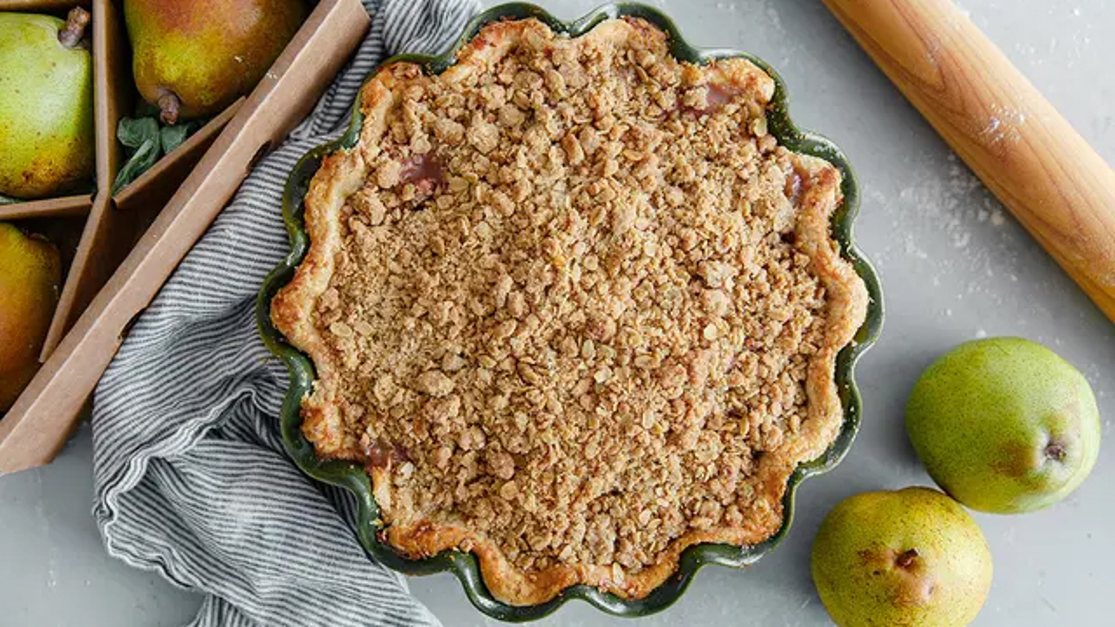 Pear crumble pie next to a box of pears.