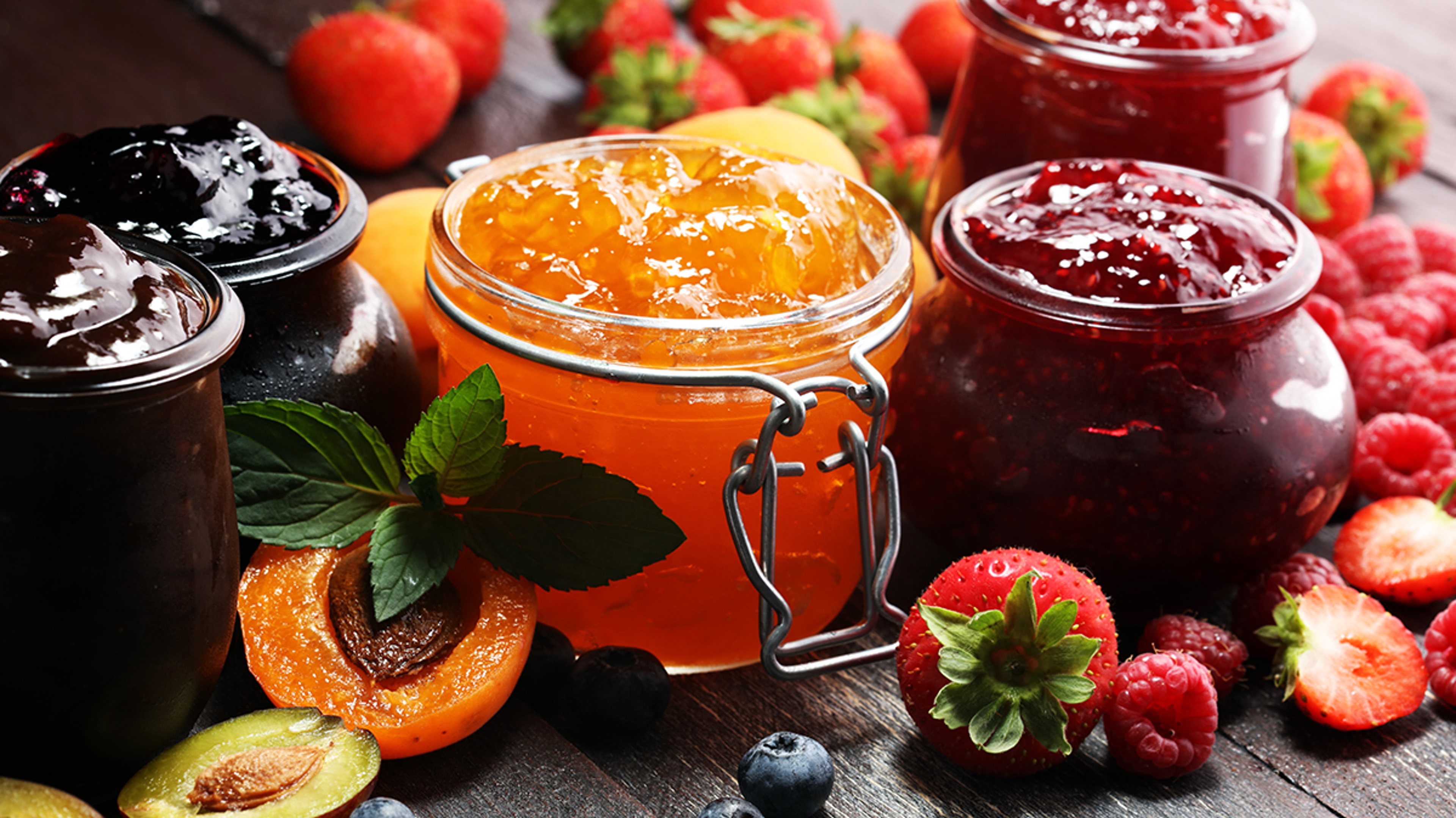 assortment of jams, seasonal berries, apricot, mint and fruits. marmalade or confiture