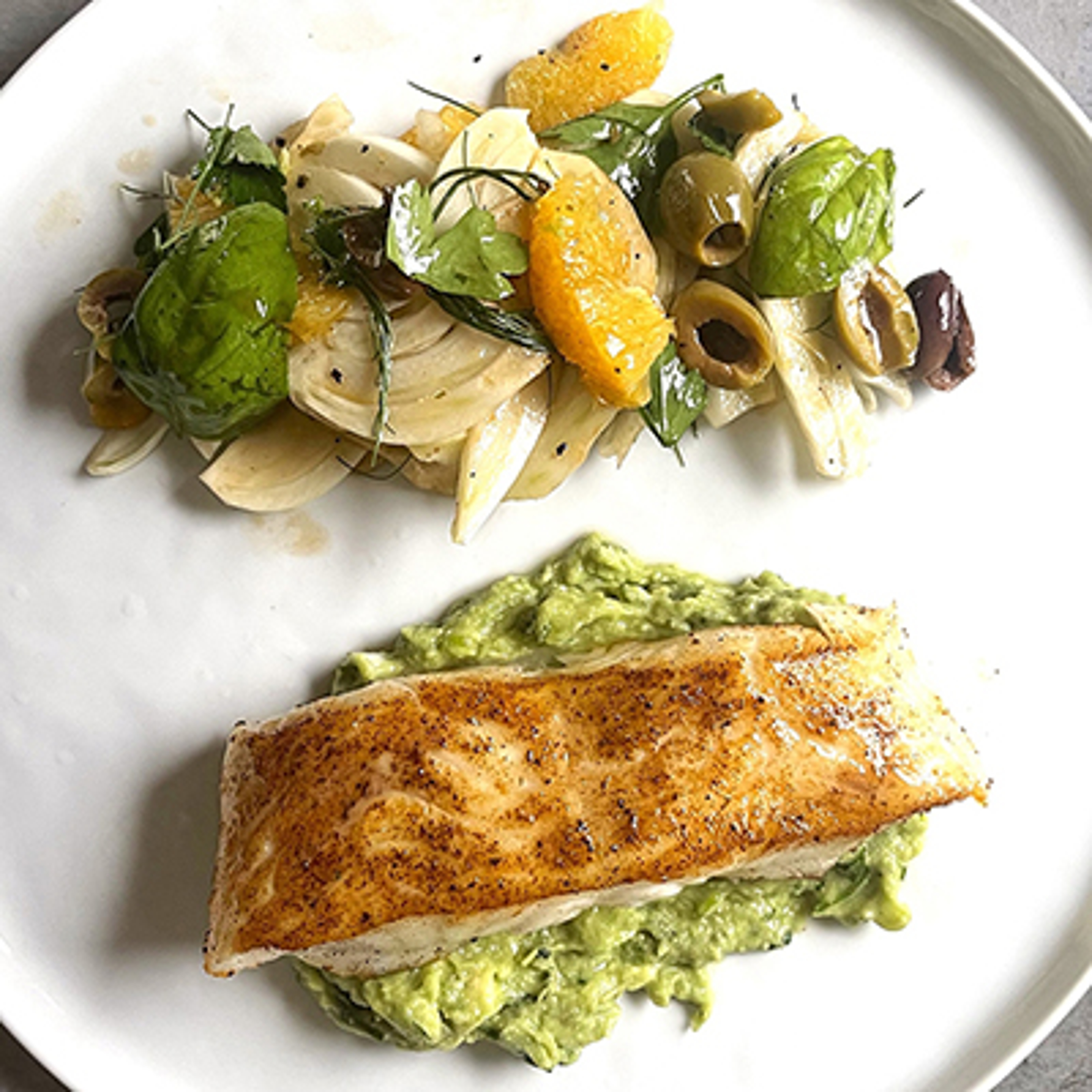 Summer fish recipes with a plate of cooked fish and salad.