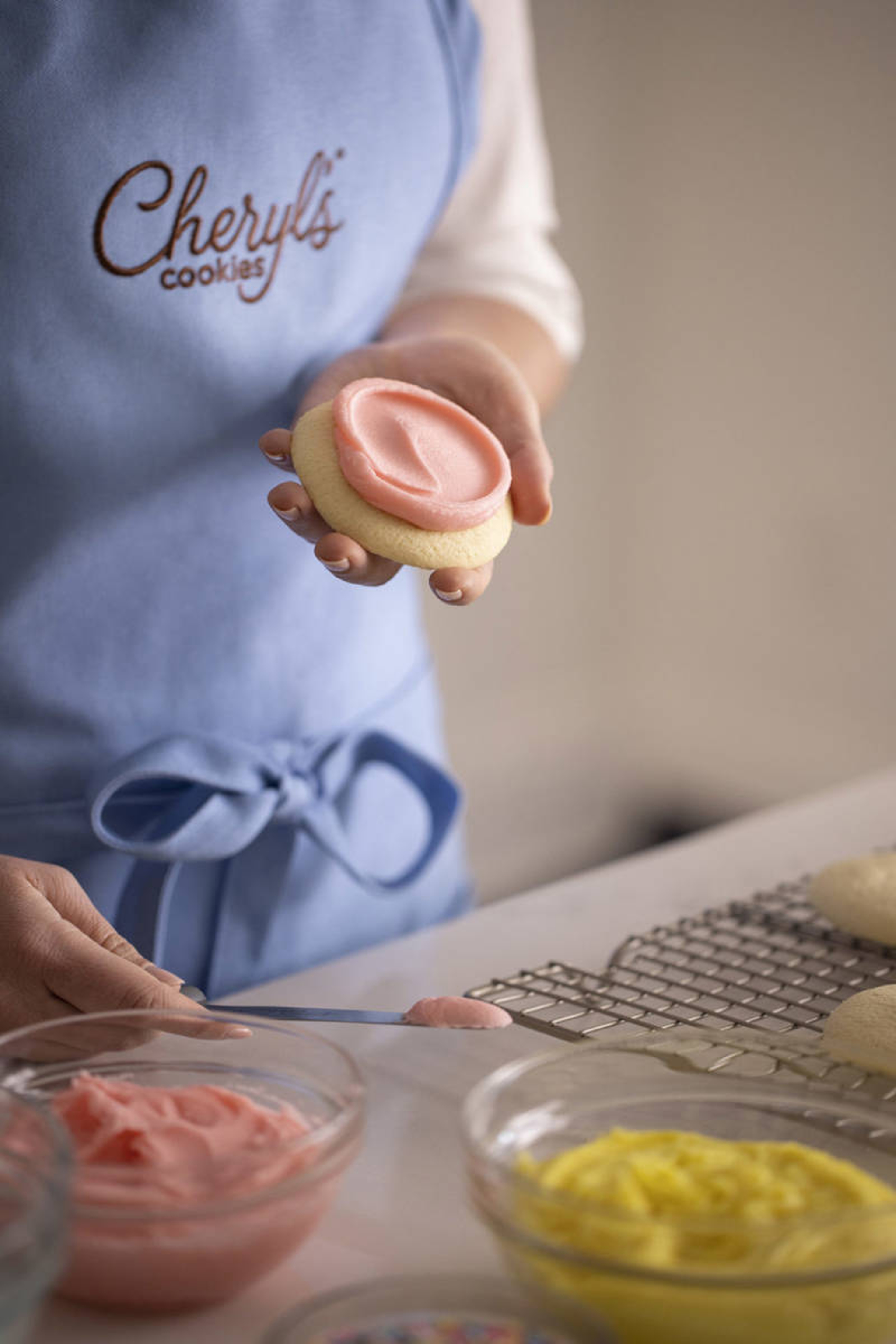 facts about buttercream woman spreading buttercream on cookies