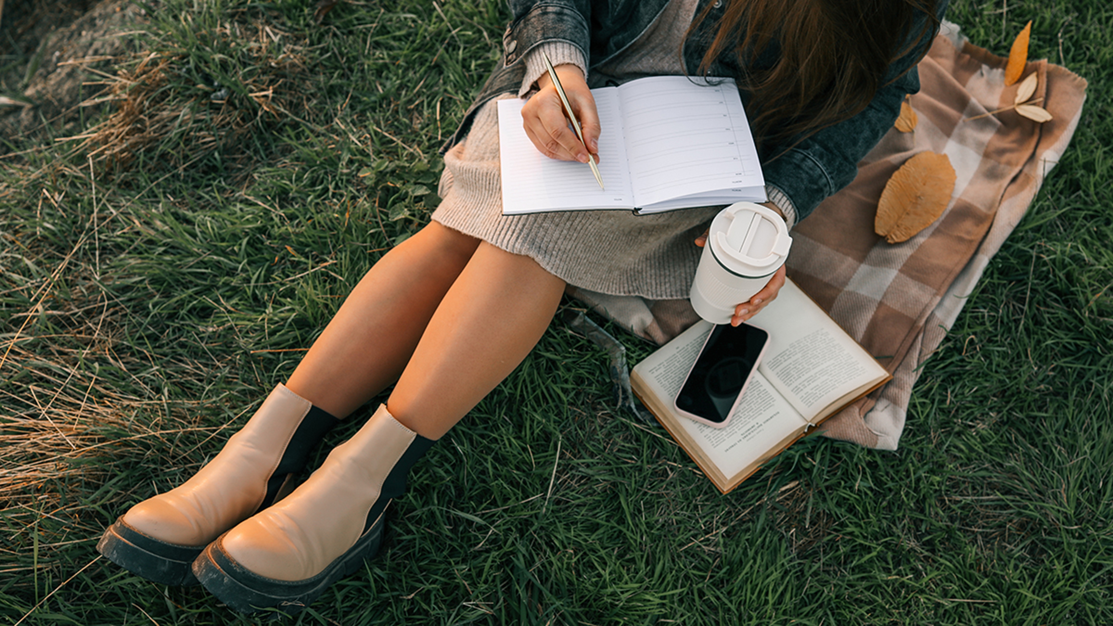 Woman sitting outside writing in her journal.