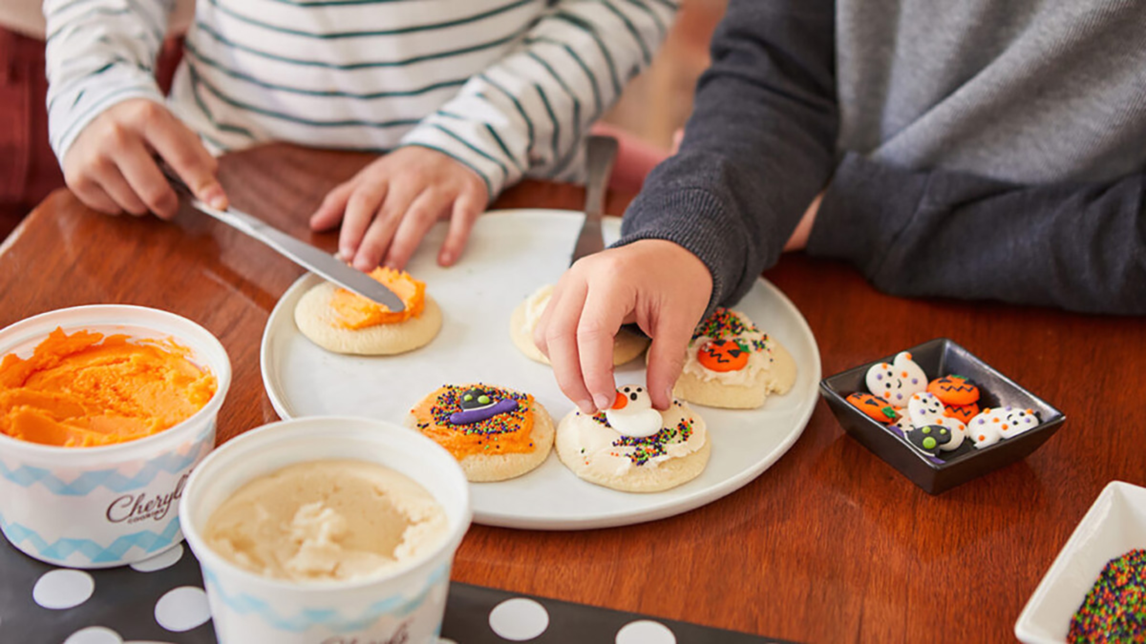 Kids decorating cookies for Halloween.