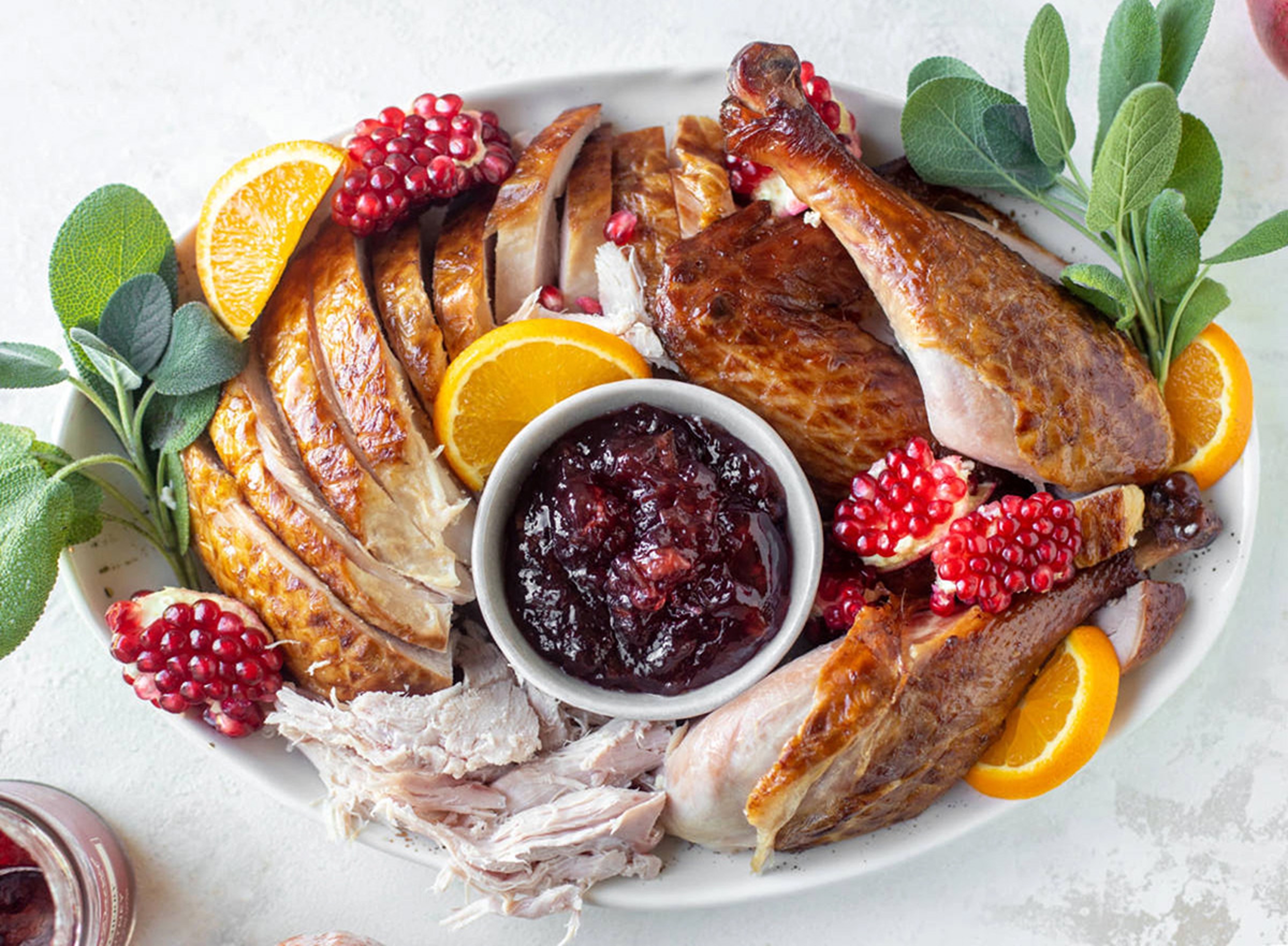 Platter of smoked turkey with pomegranates and sage.