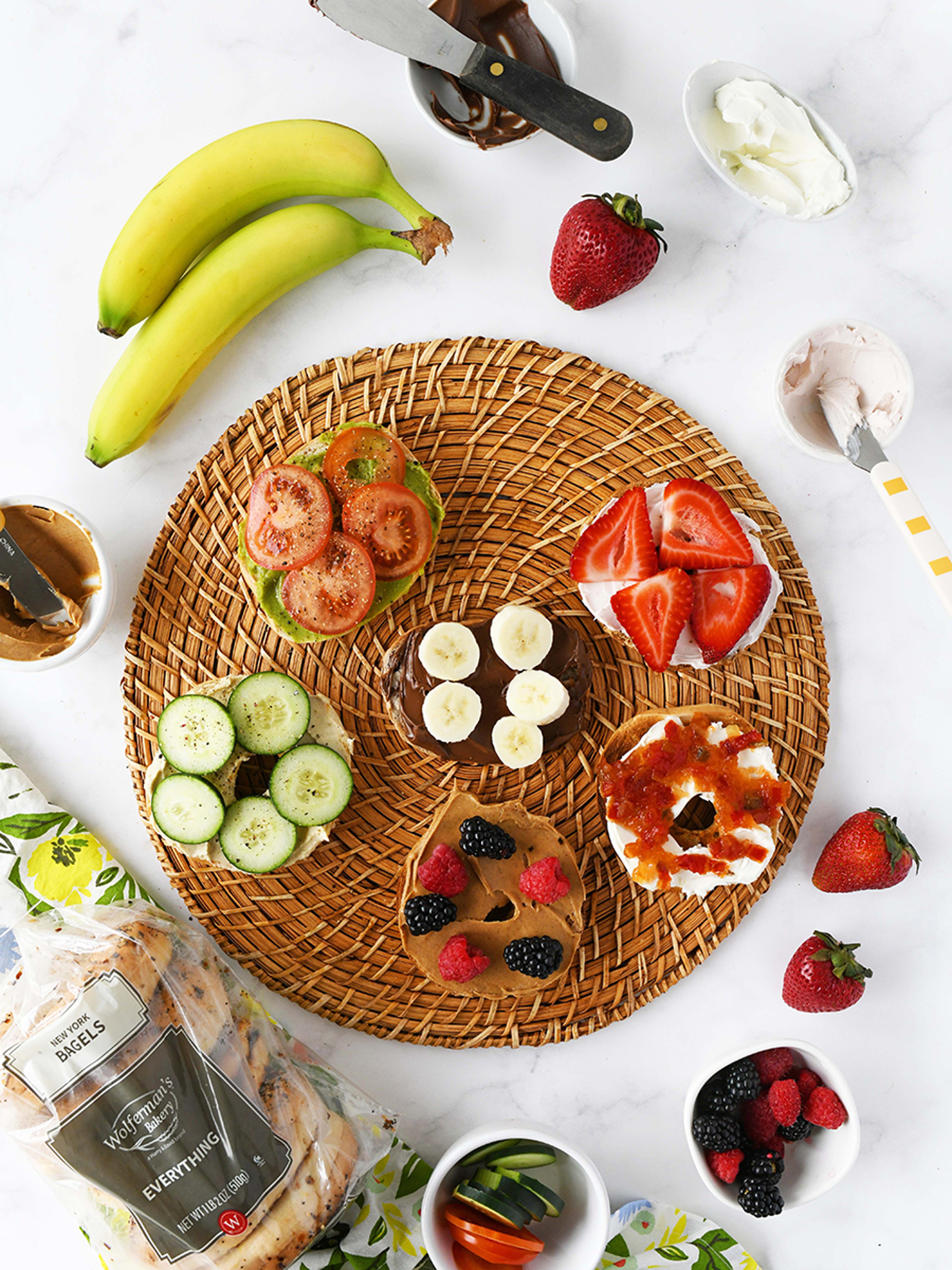 Multiple types of bagel sandwiches on a wicker mat.