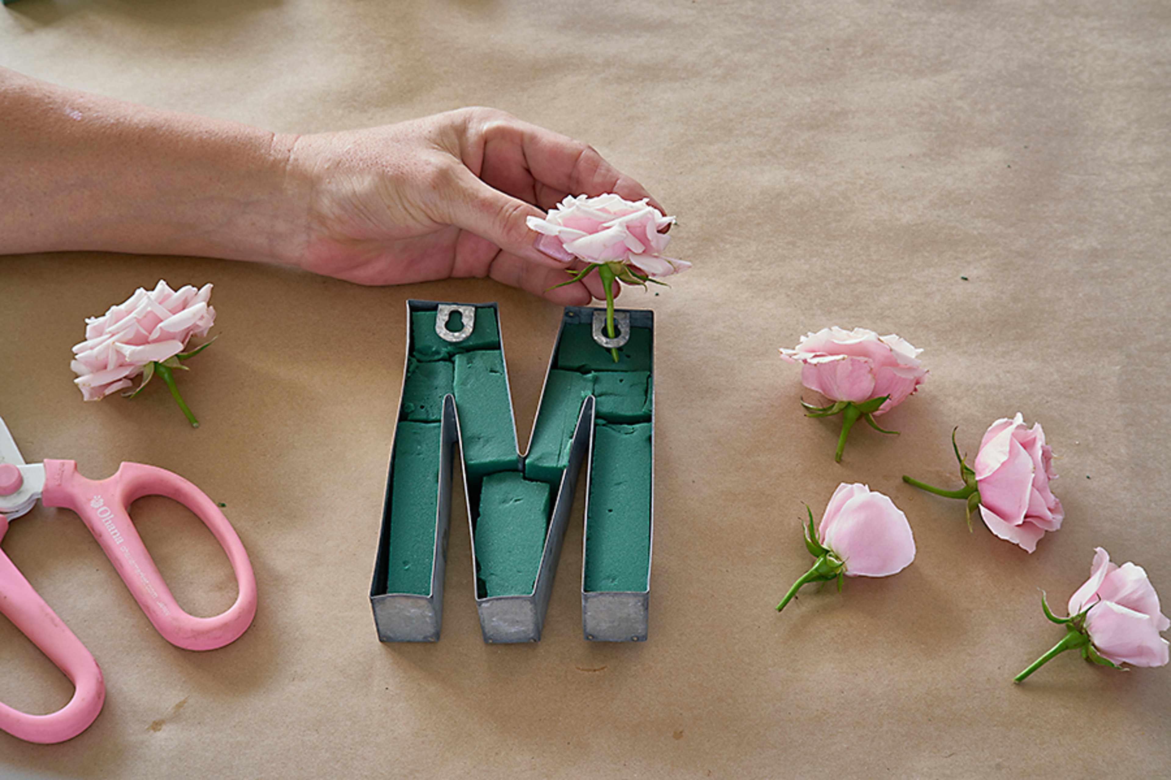 example of taking the cut flowers and sticking them into the floral foam inside the metal shapes