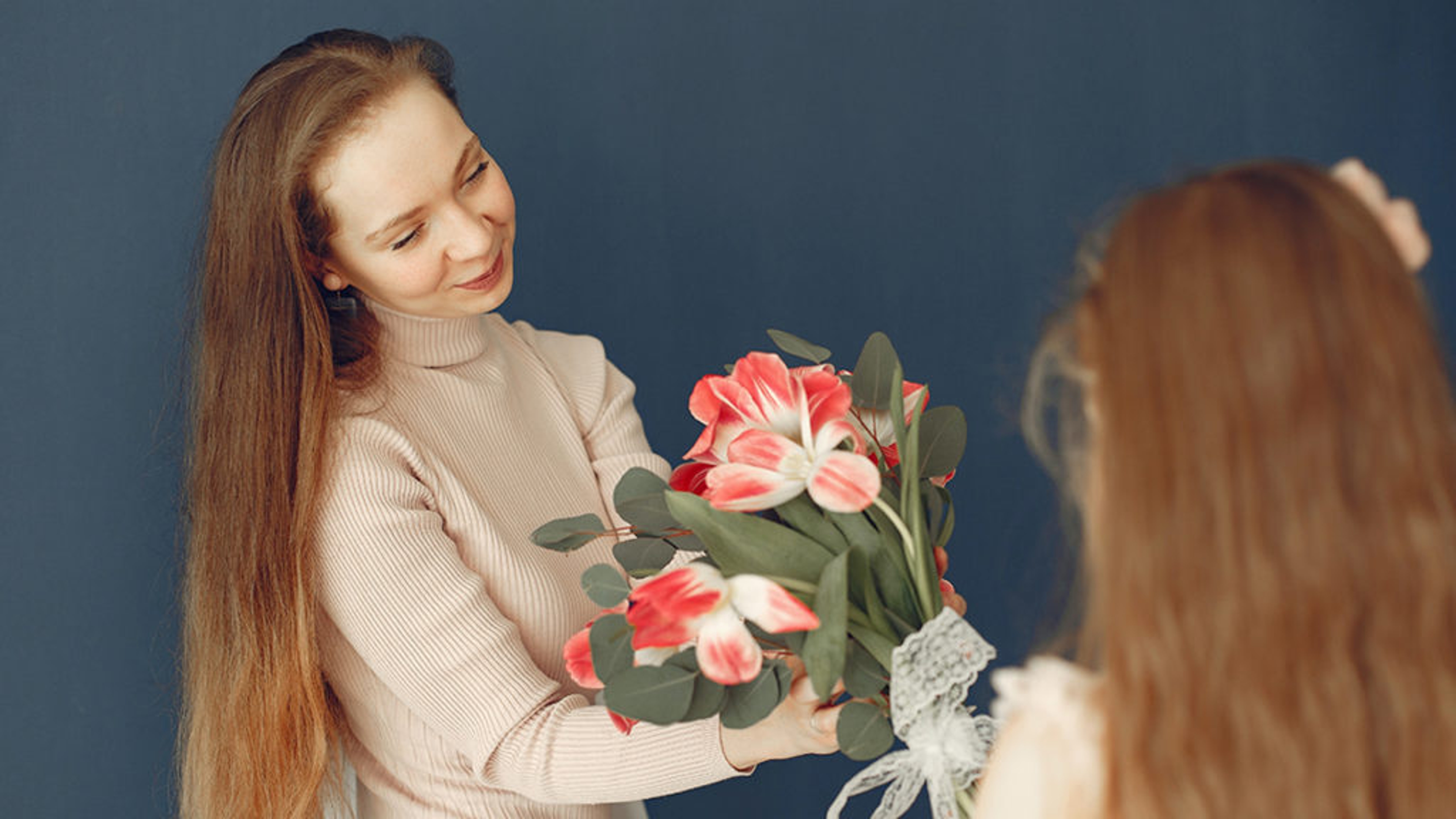 Woman accepting flowers from a young girl.