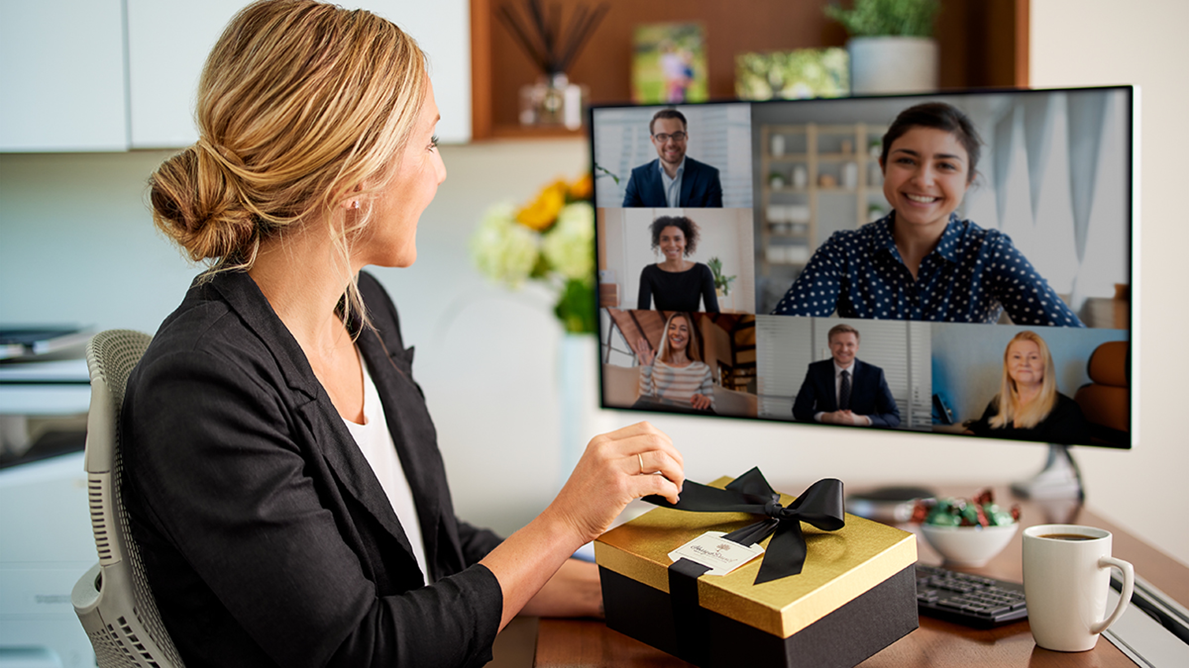 Remote worker opening a gift while on a work call.