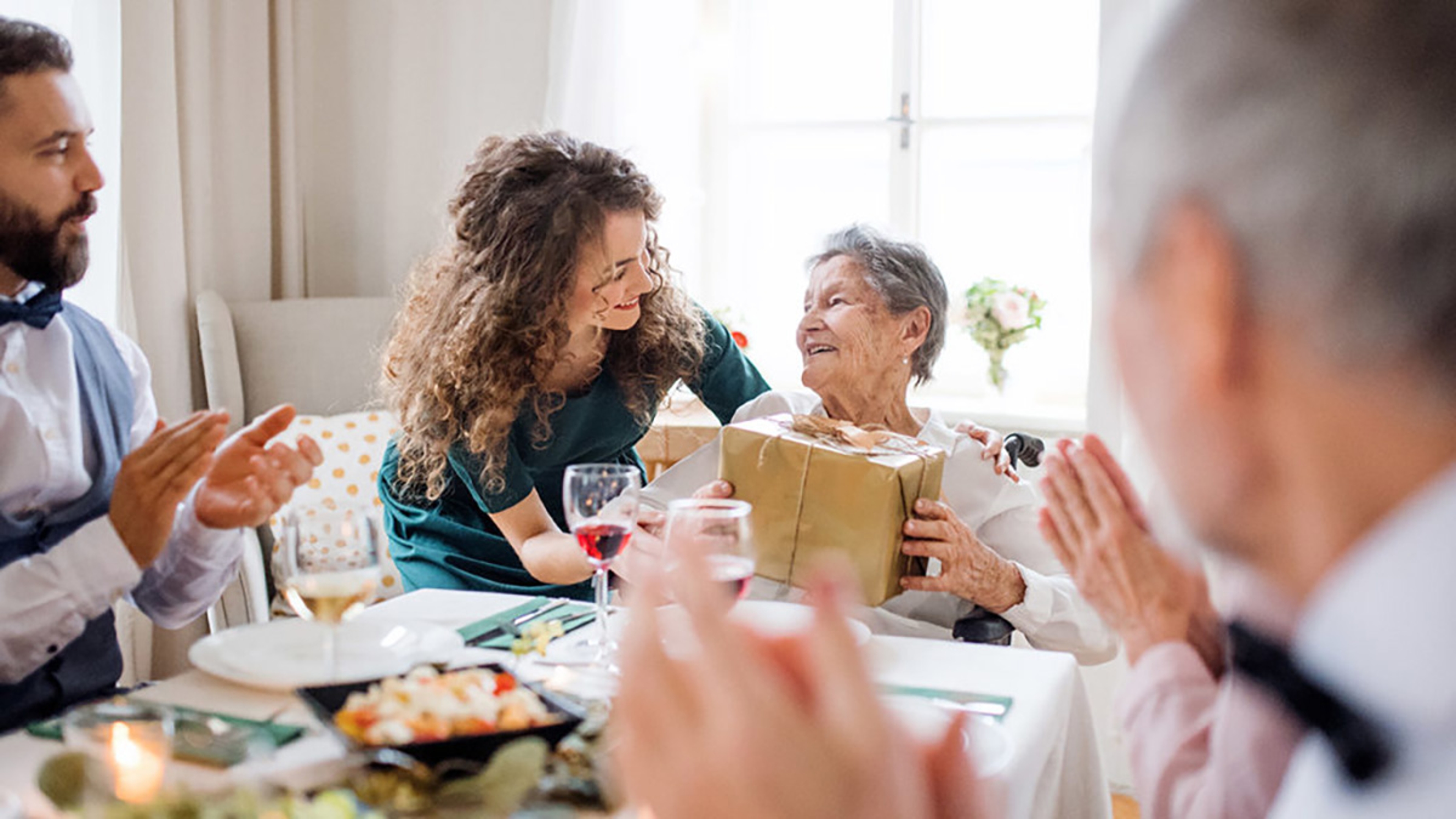 Older woman receiving a birthday present from a young woman.