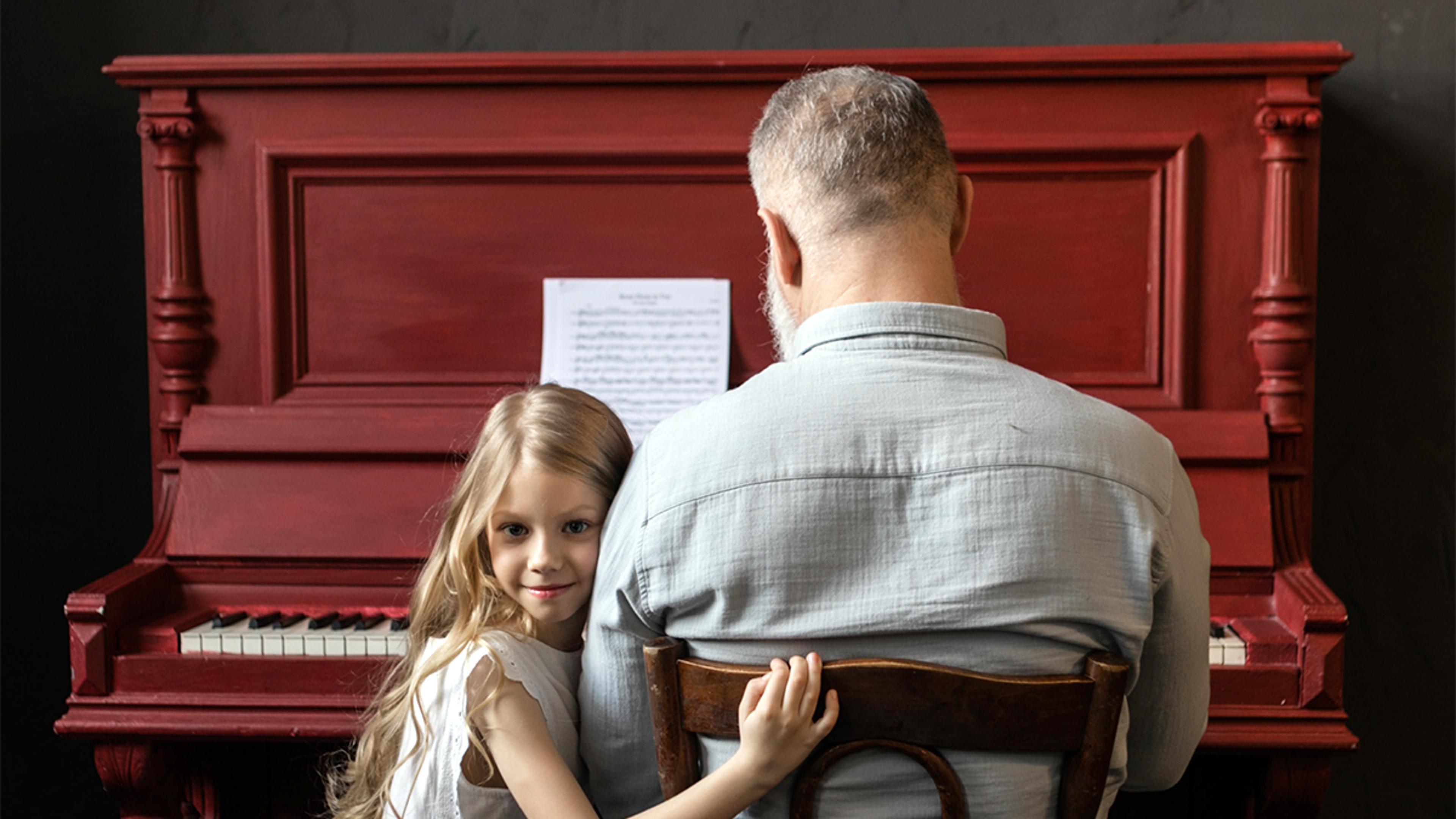 Grandparent teaching grandkid musical instrument