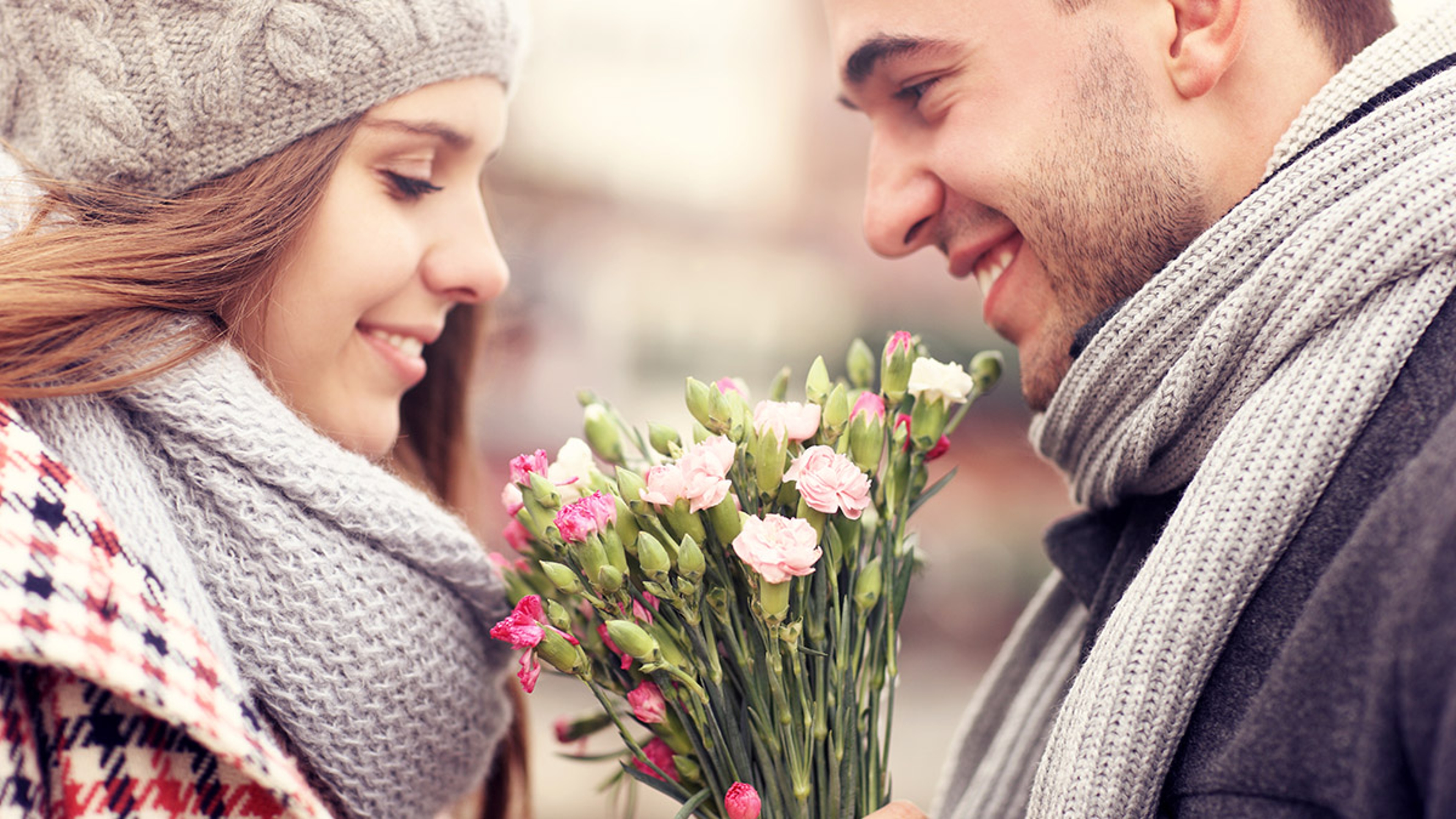 Article Cards Featured Image history of gifting flowers with man giving woman flowers