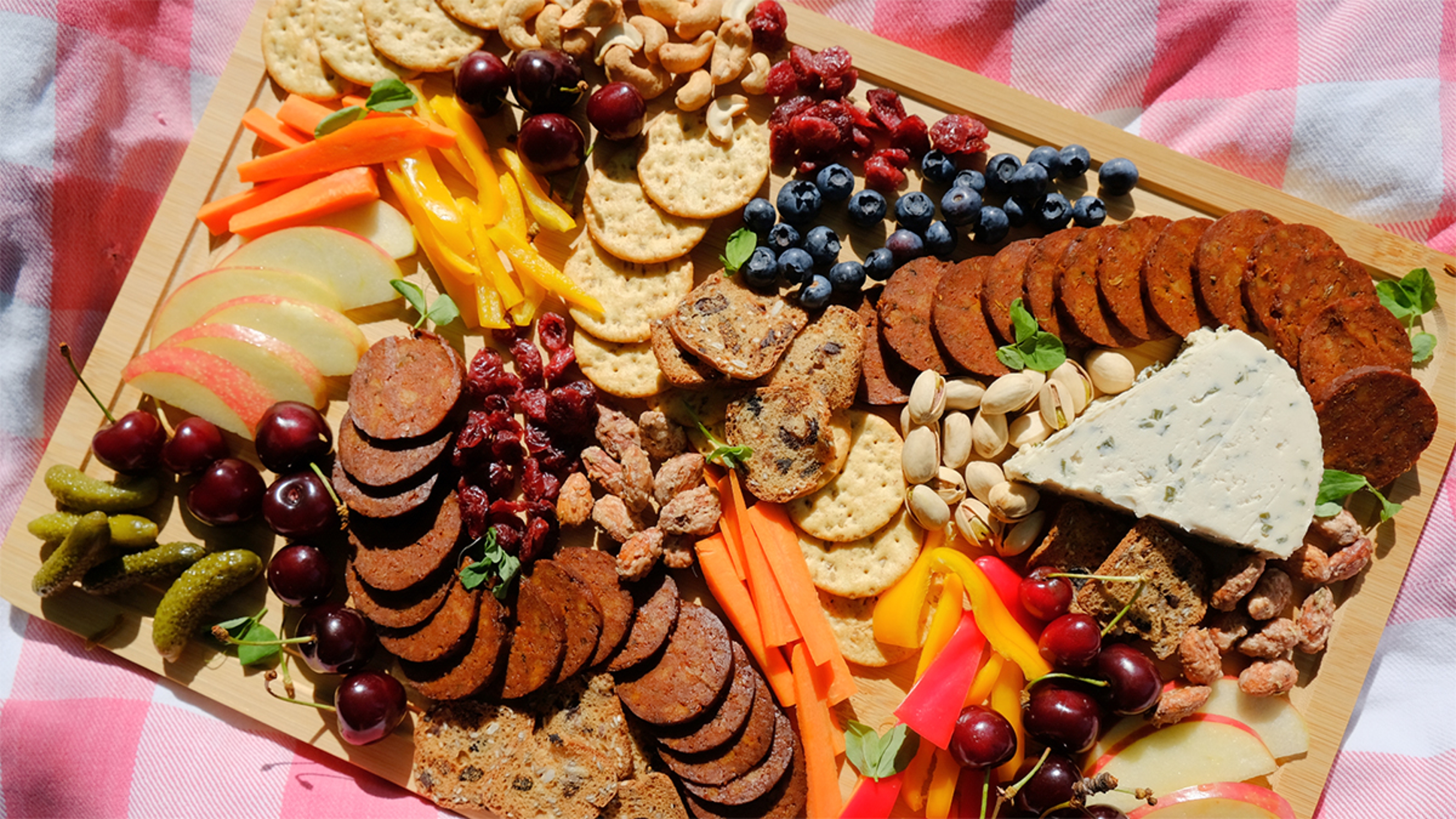 Vegan charcuterie board on a picnic blanket.