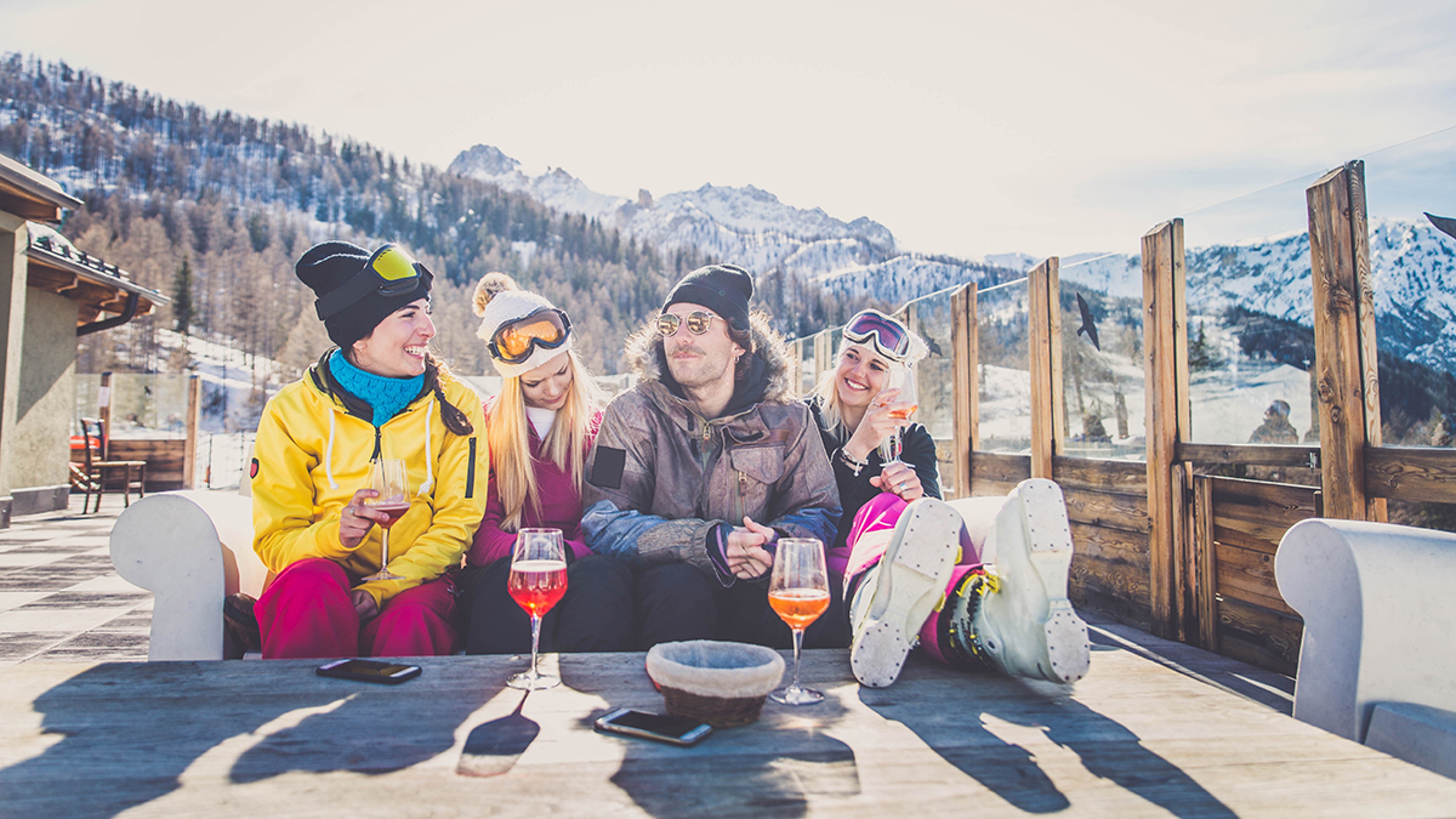 Group of friends talking and having fun in a outdoor restaurant on winter holidays