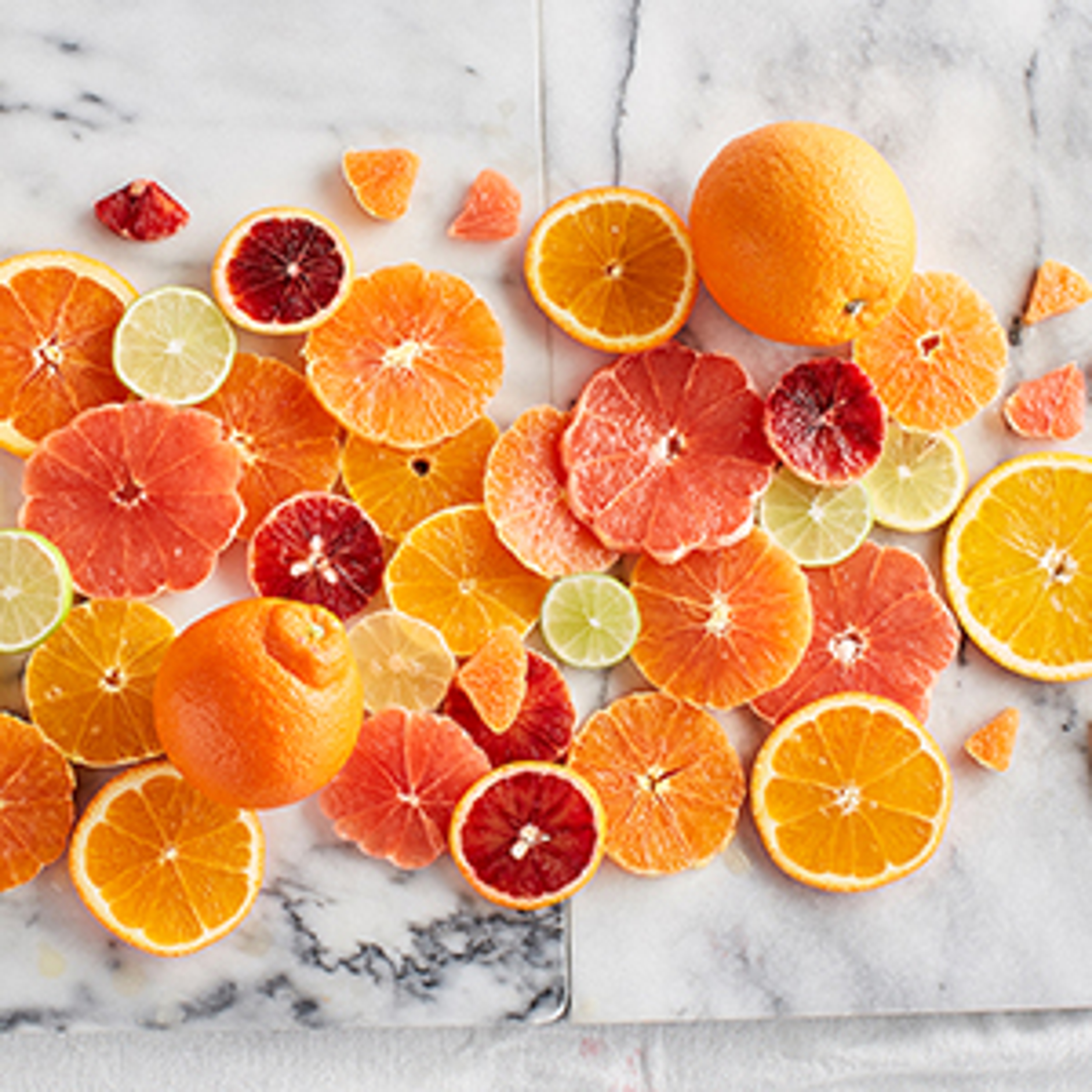 Sliced oranges on a marble counter top.