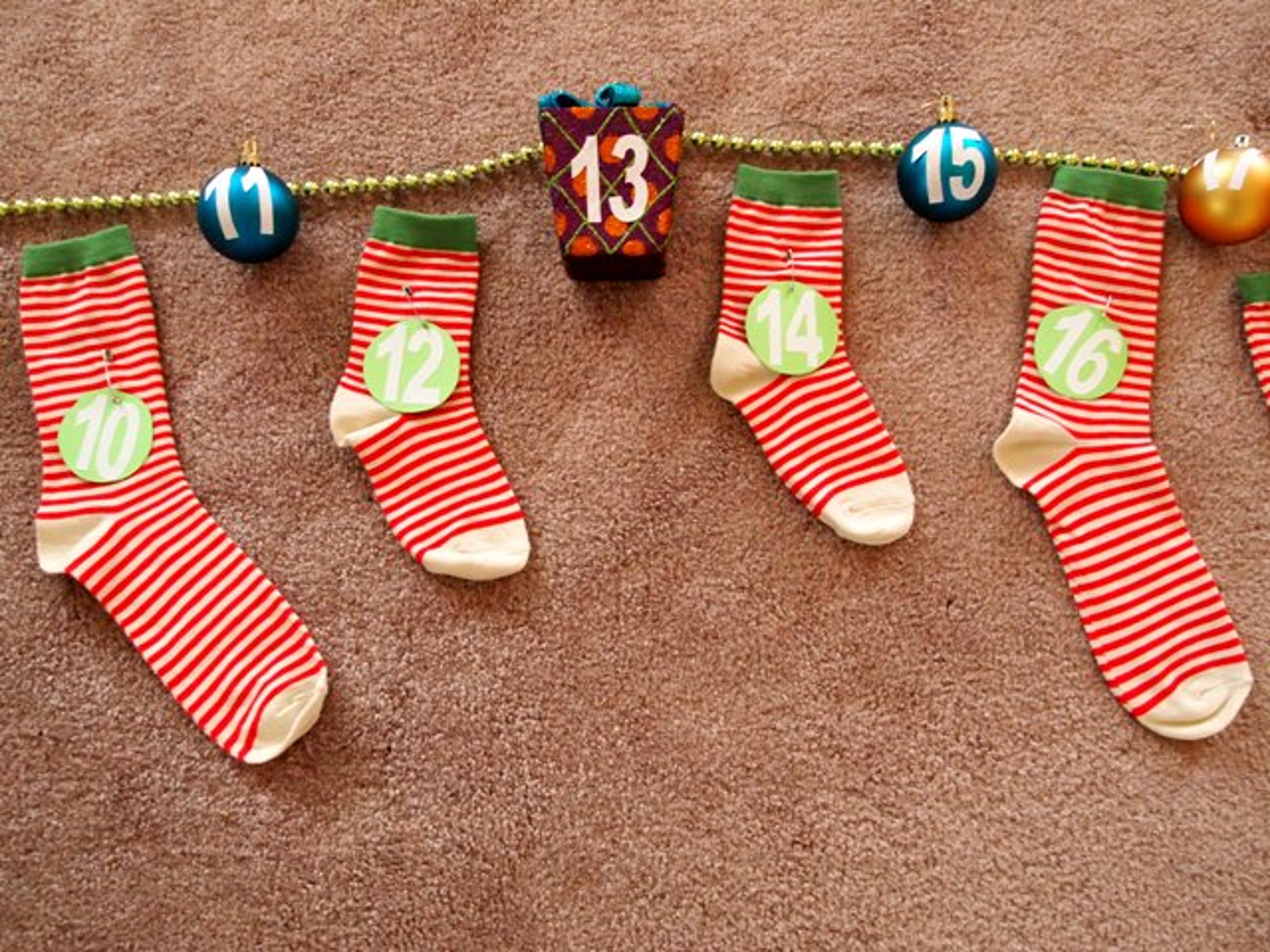 DIY Christmas Ornaments and Socks Strung up on Garland to Make an Advent Calendar