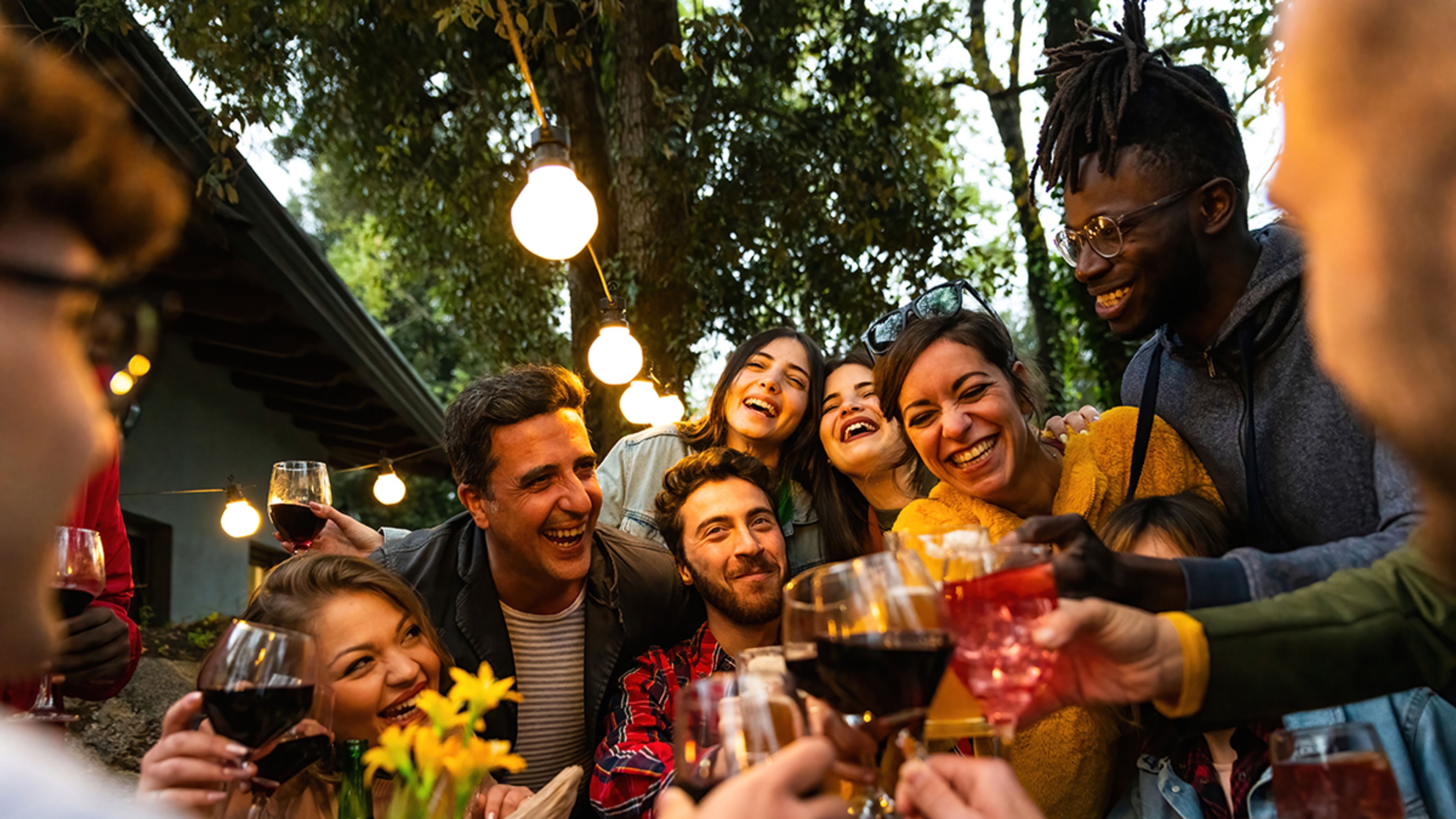 Group of people toasting with wine and beer Happy friends having fun outdoor