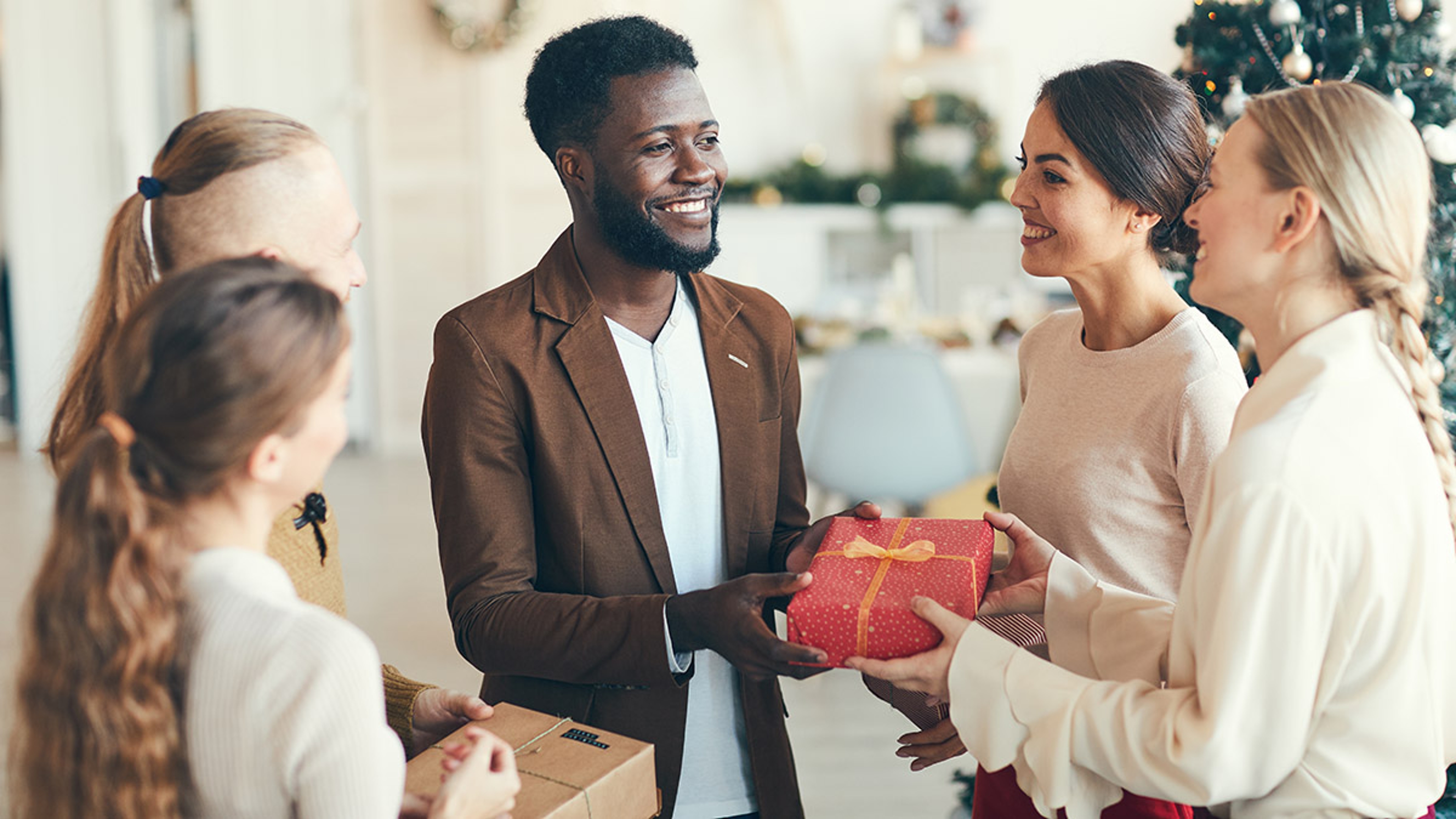 Article Cards Featured Image man giving gift to holiday hostess