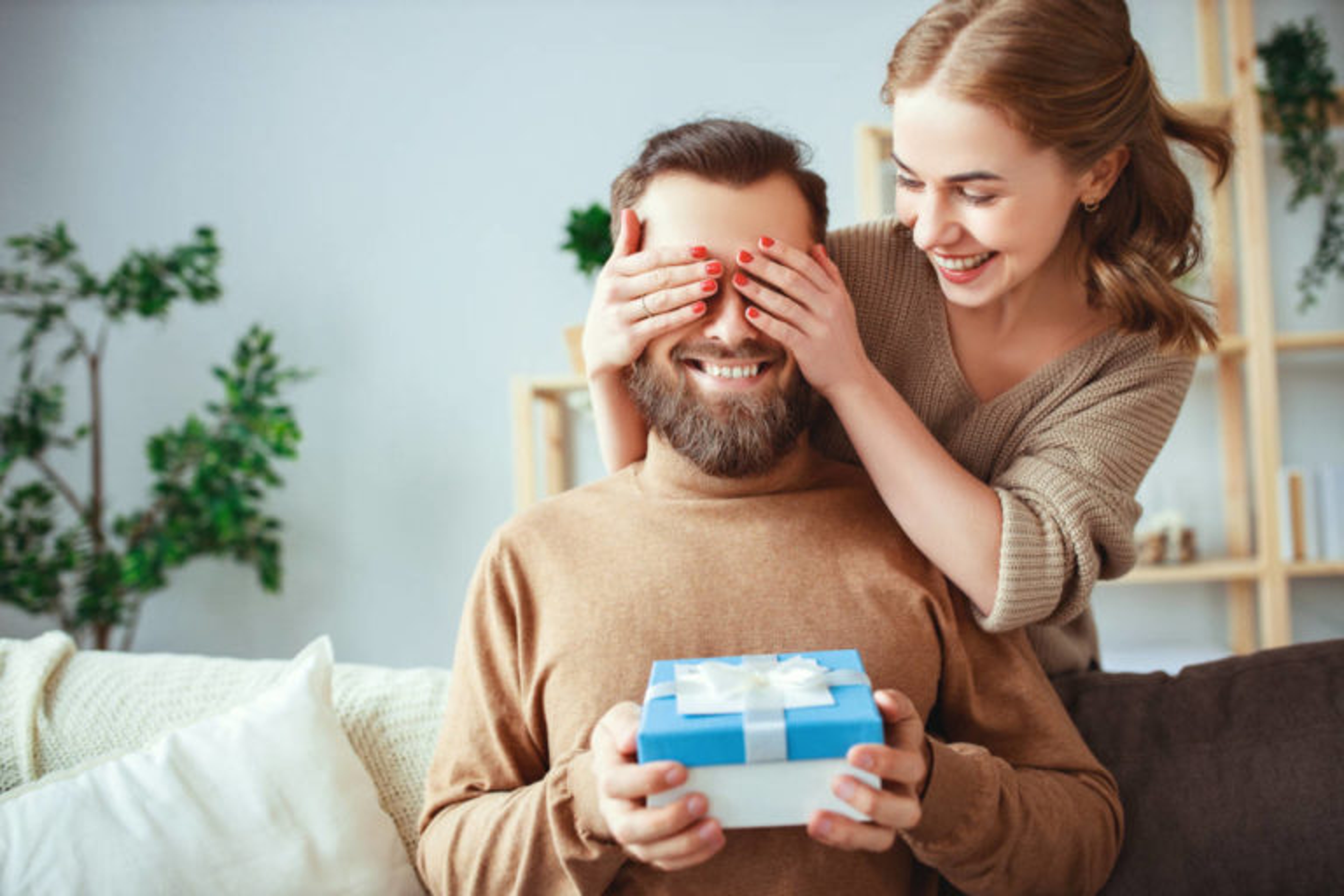 Happy married couple man and woman give a gift for the holiday