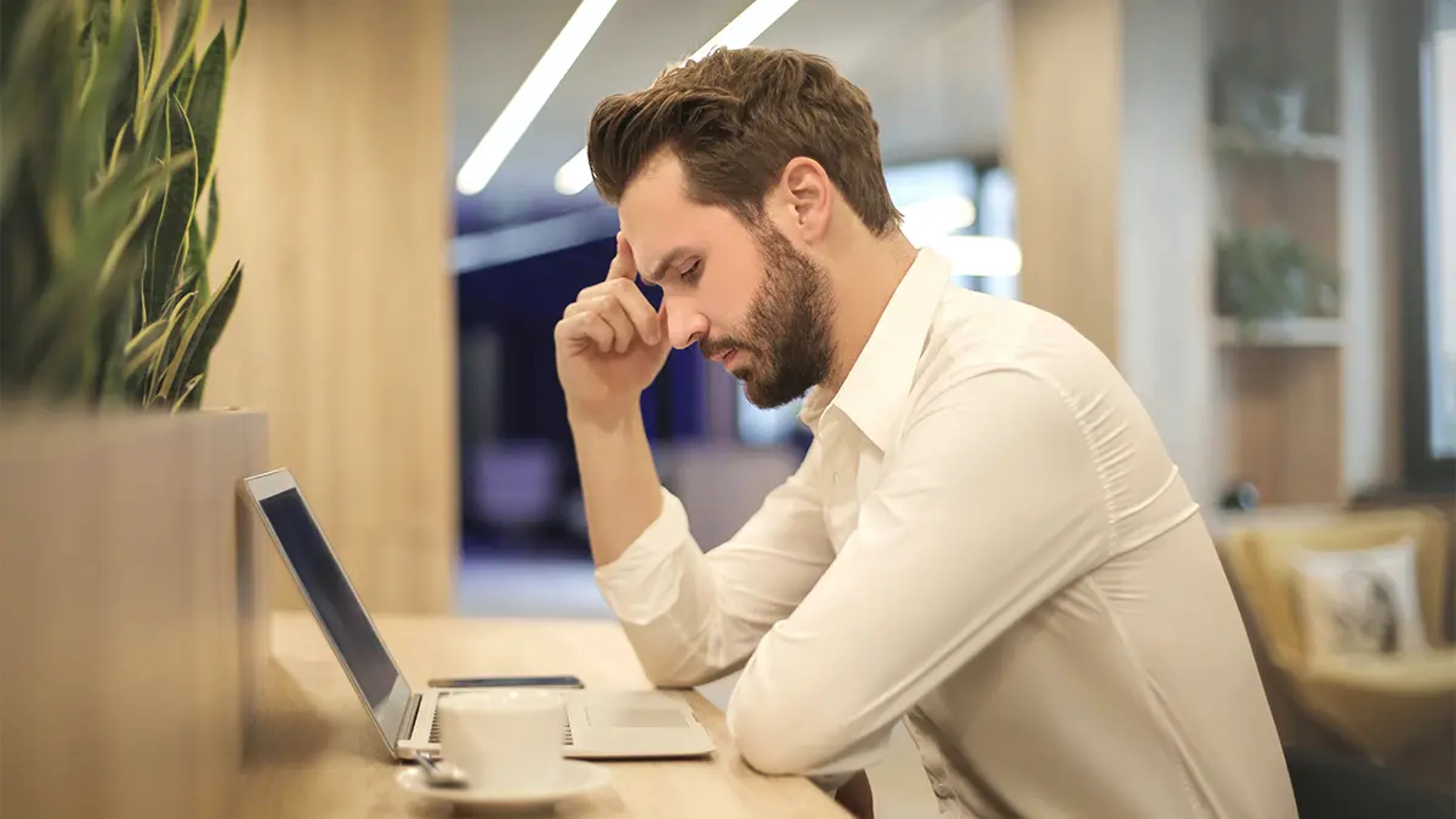 Online support communities with a man sitting a desk looking at a computer.