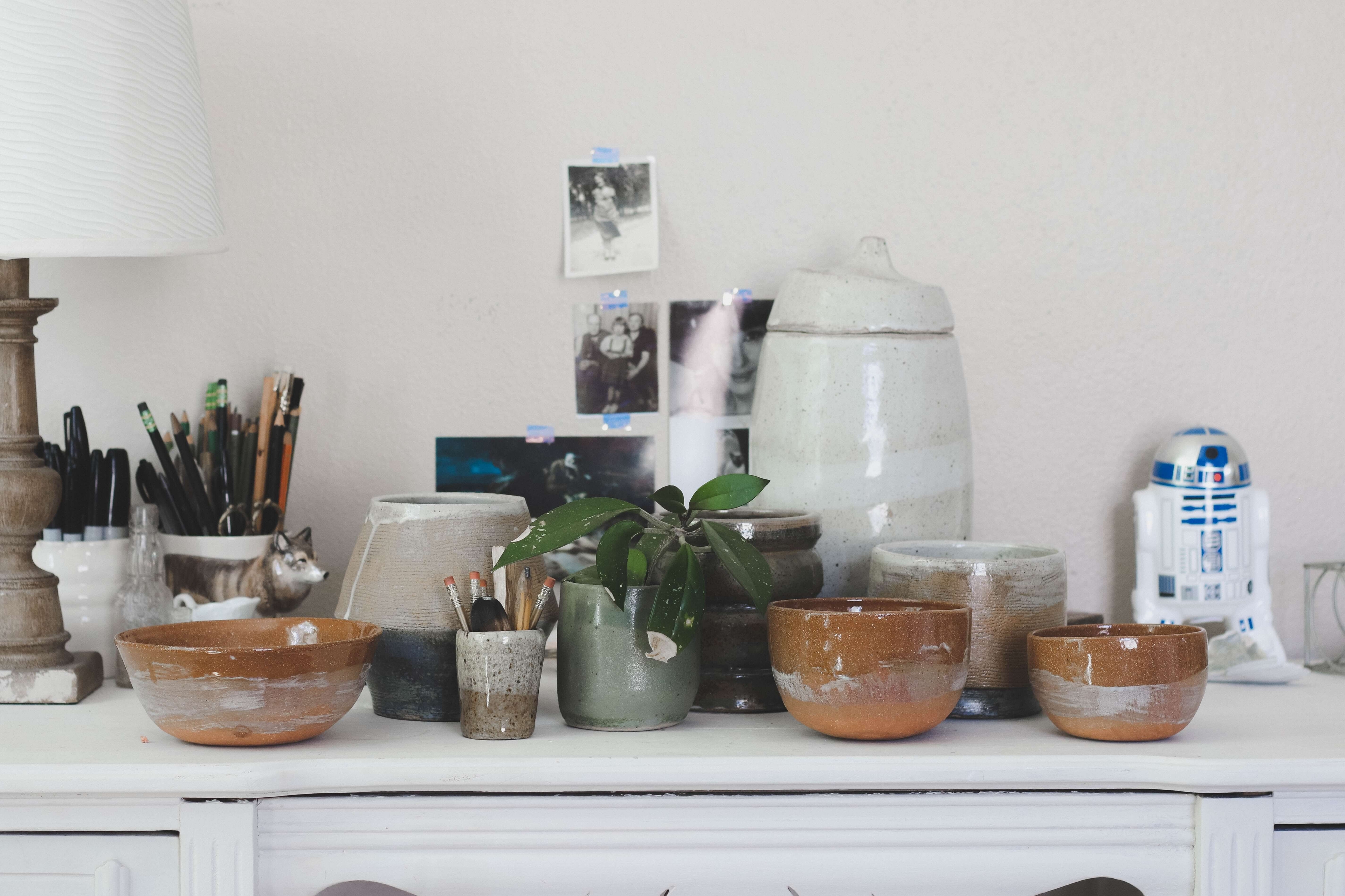 Plants on a table surrounded by earthernware bowls