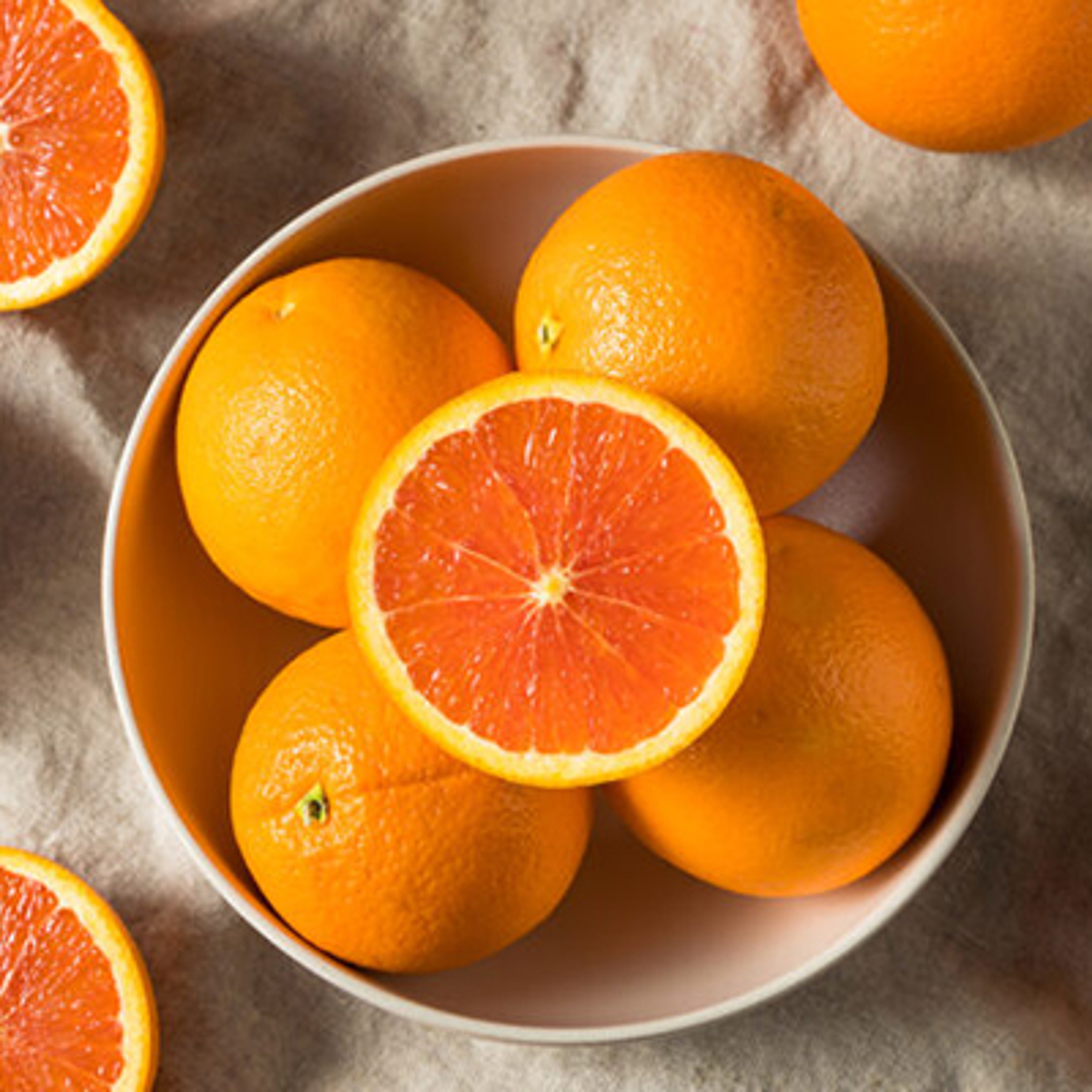 Bowl of cara cara oranges, whole and sliced.