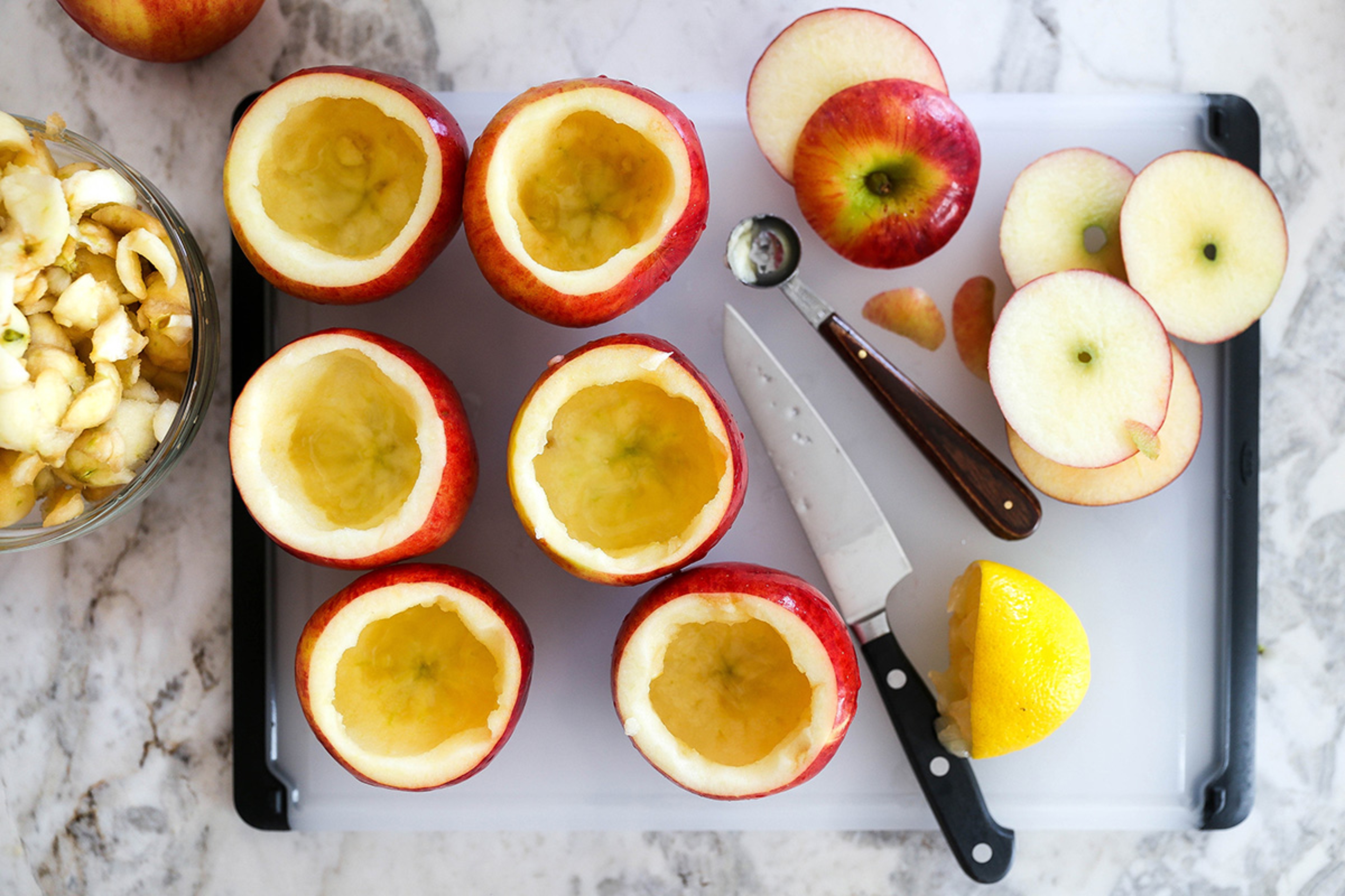 Process of making an apple cider cocktail in apple cups.
