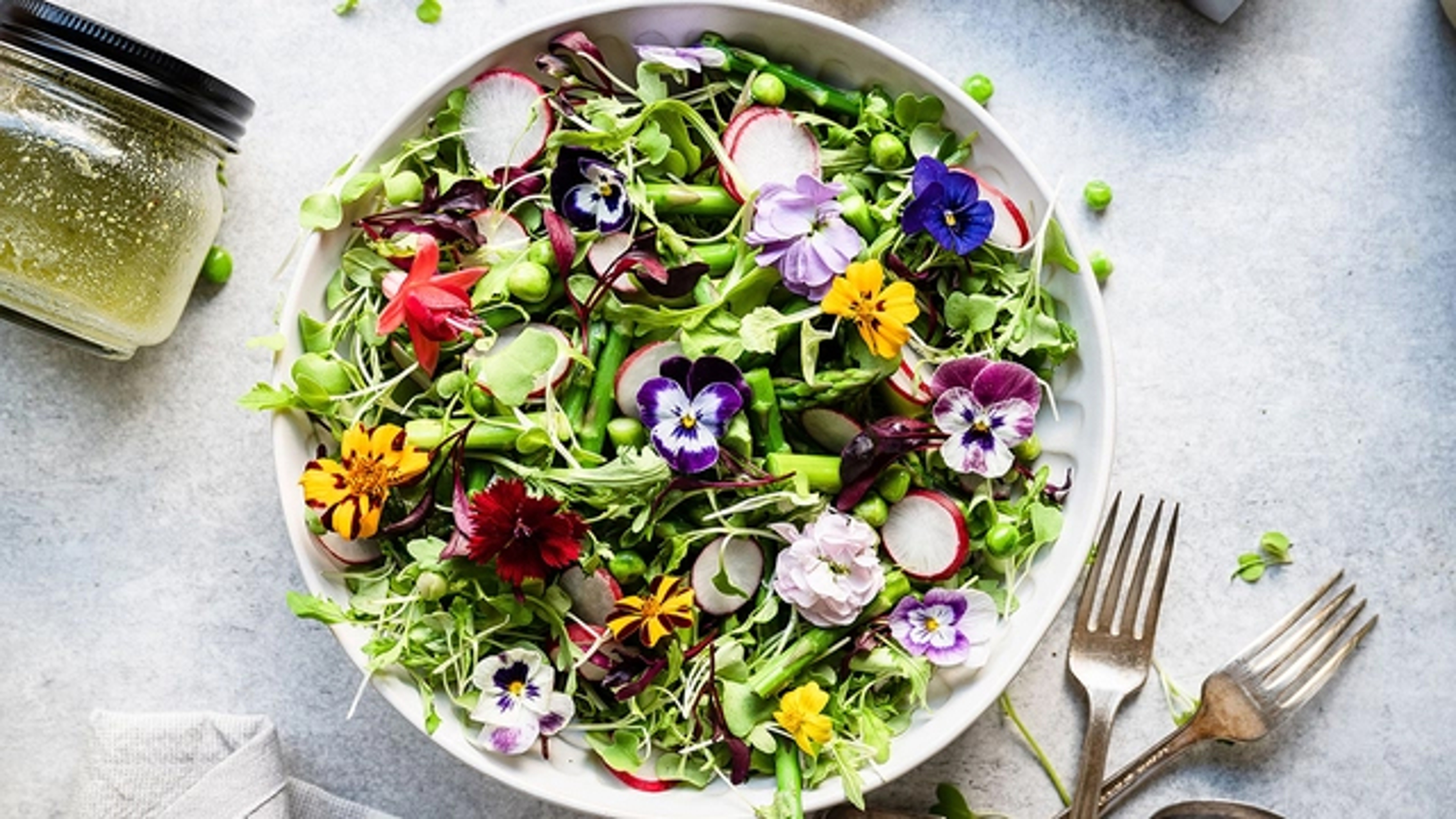 A salad with flowers and greens.