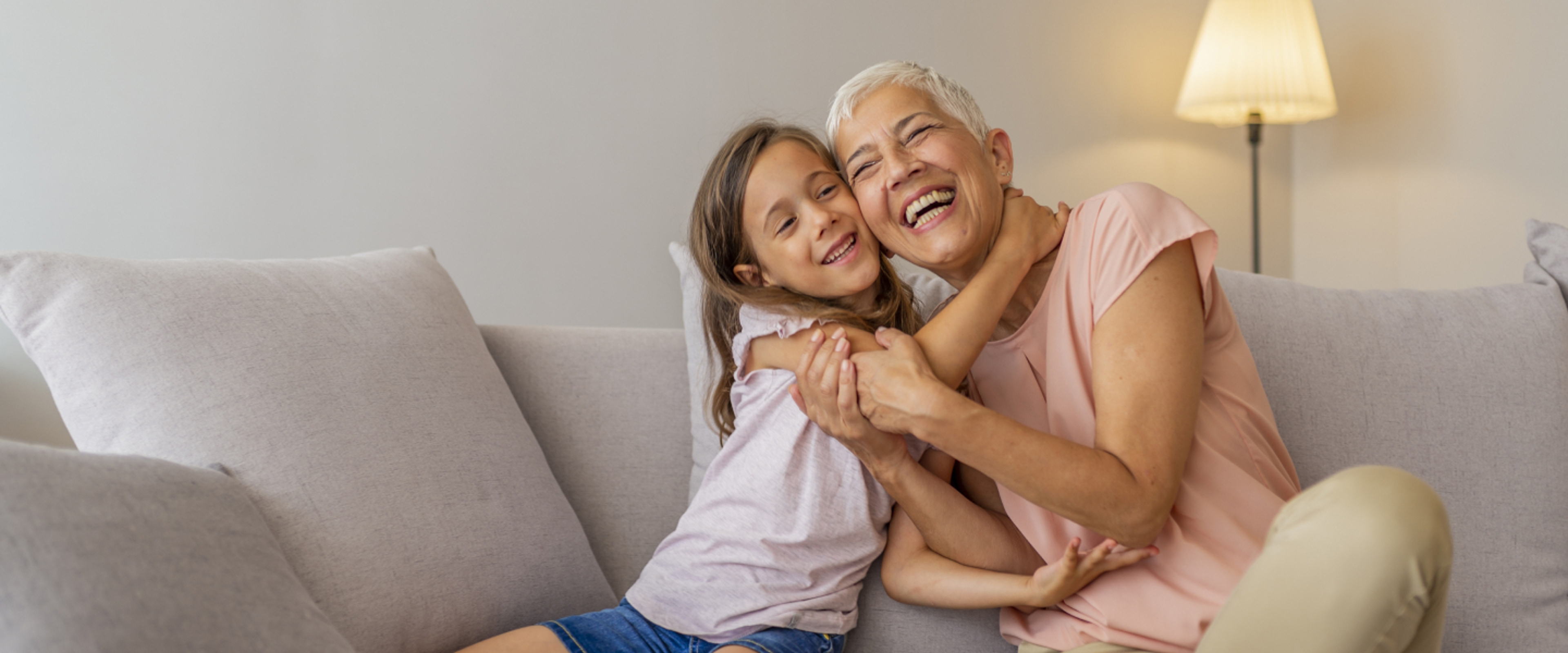 Grandma and Grandkid hugging on a couch