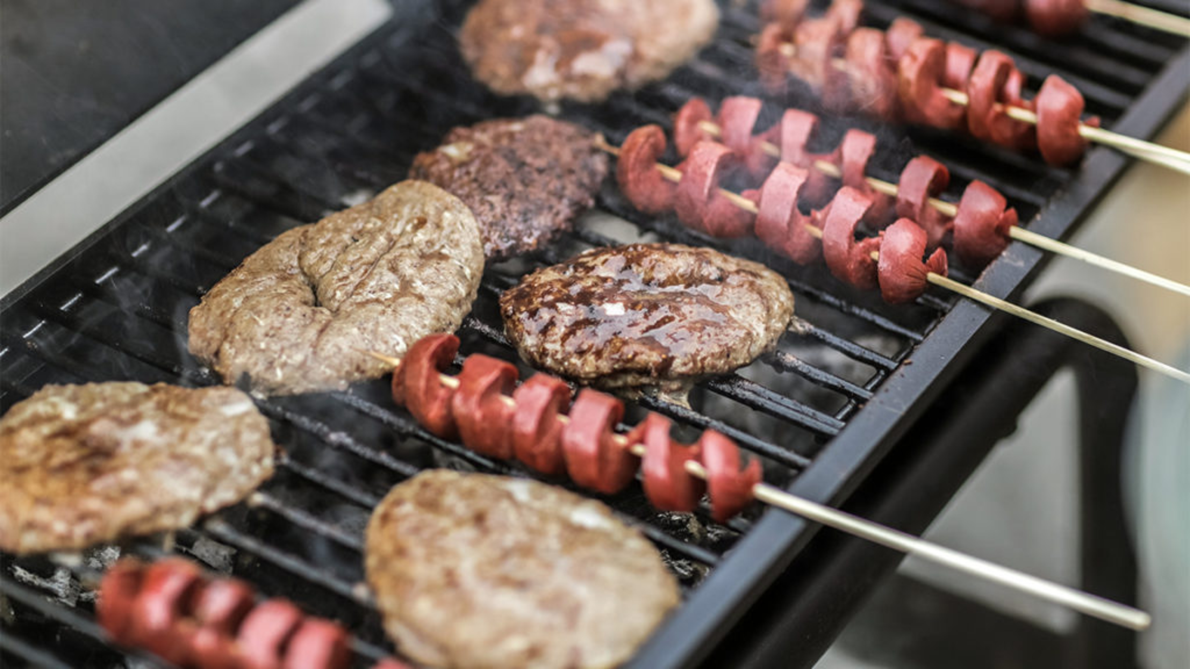 Food on the grill for a tailgate party.