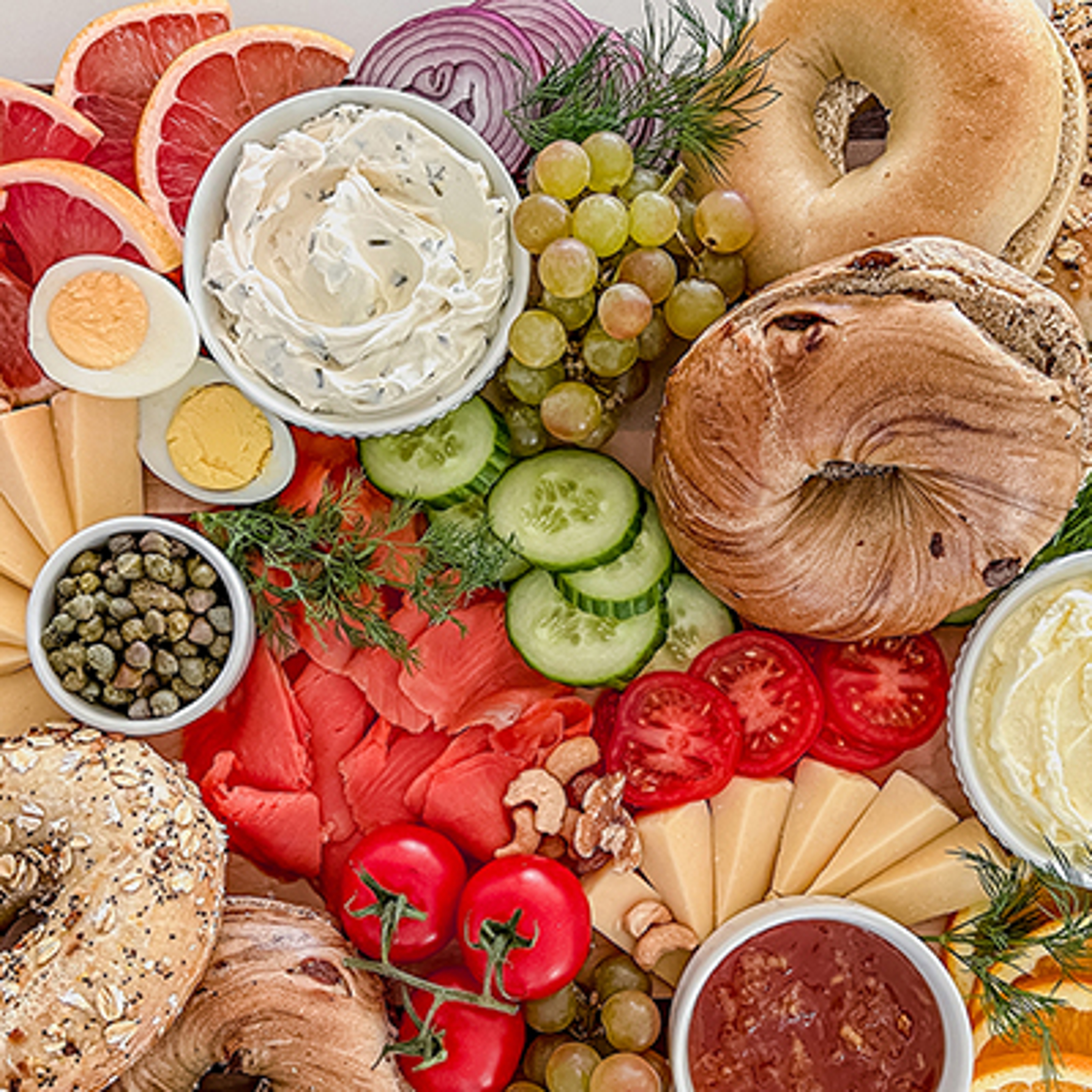 Breakfast fish recipes with a spread of bagels and condiments on a board.