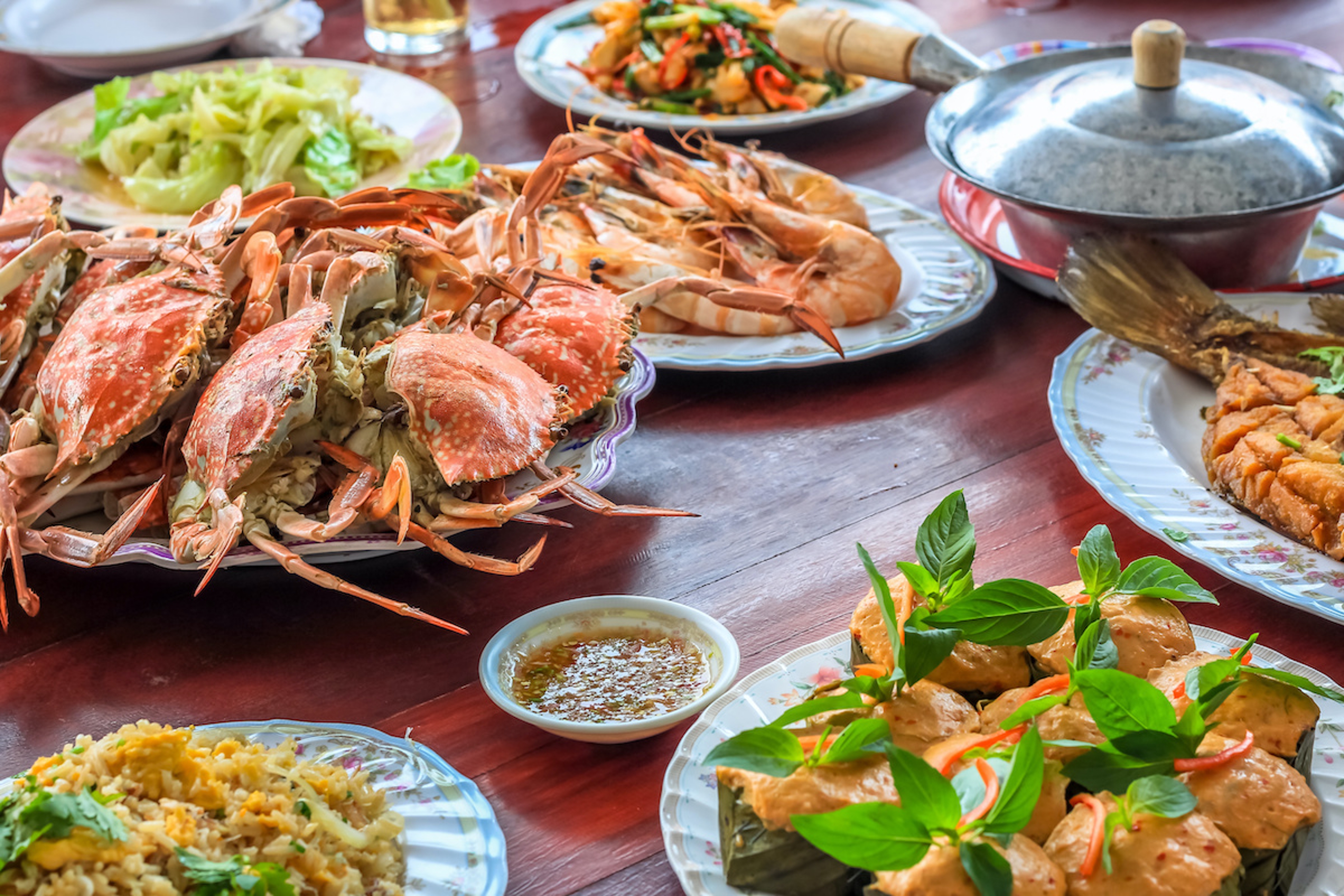 Article Cards Featured Image Thai style set of seafood insist of Thai steamed curry fish in banana leaf cups decorated with basil leaf, Hor Mok Pla steamed crab/prawn/shrimp with seafood sauce