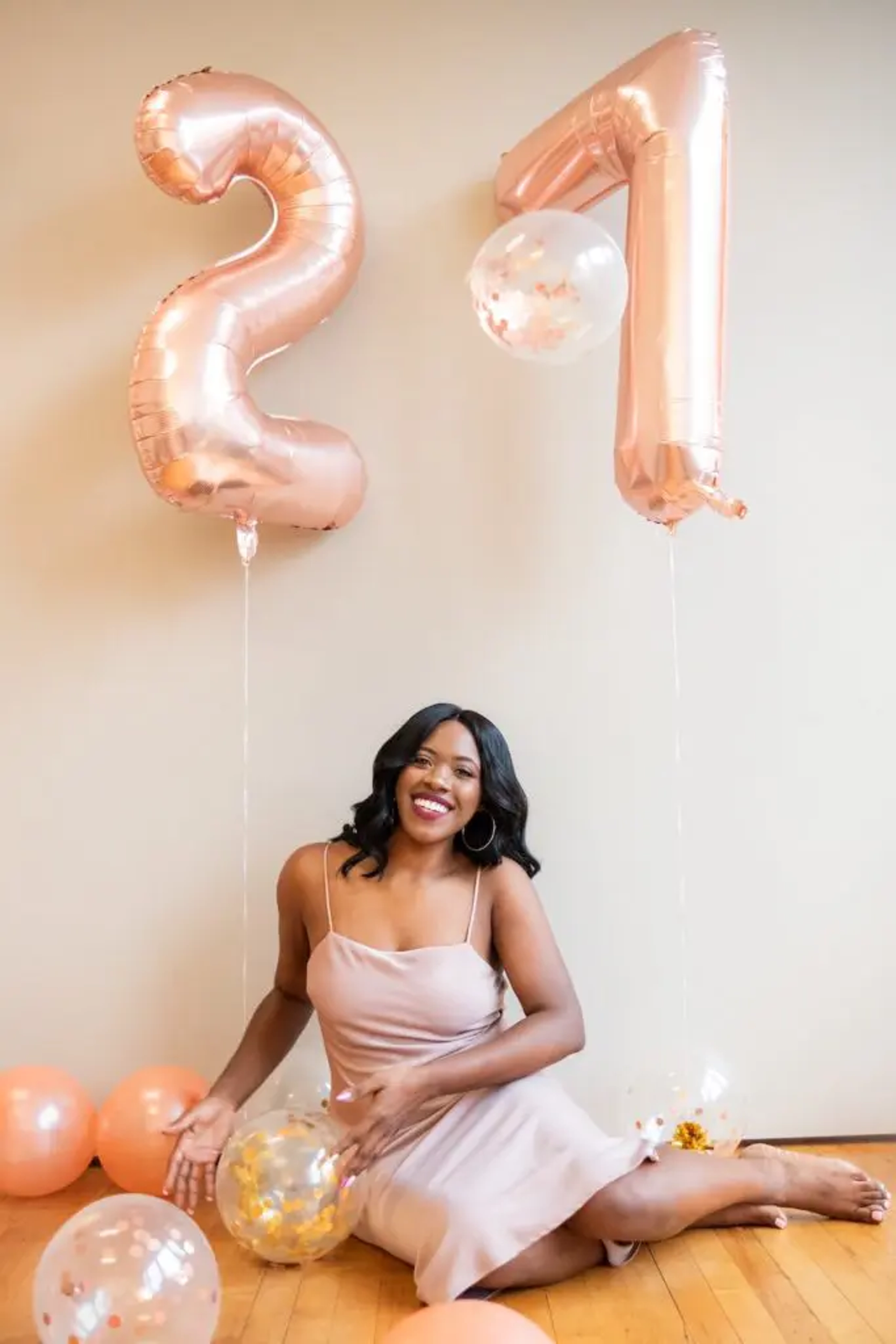 Party themes for adults with a woman sitting underneath balloons that say .