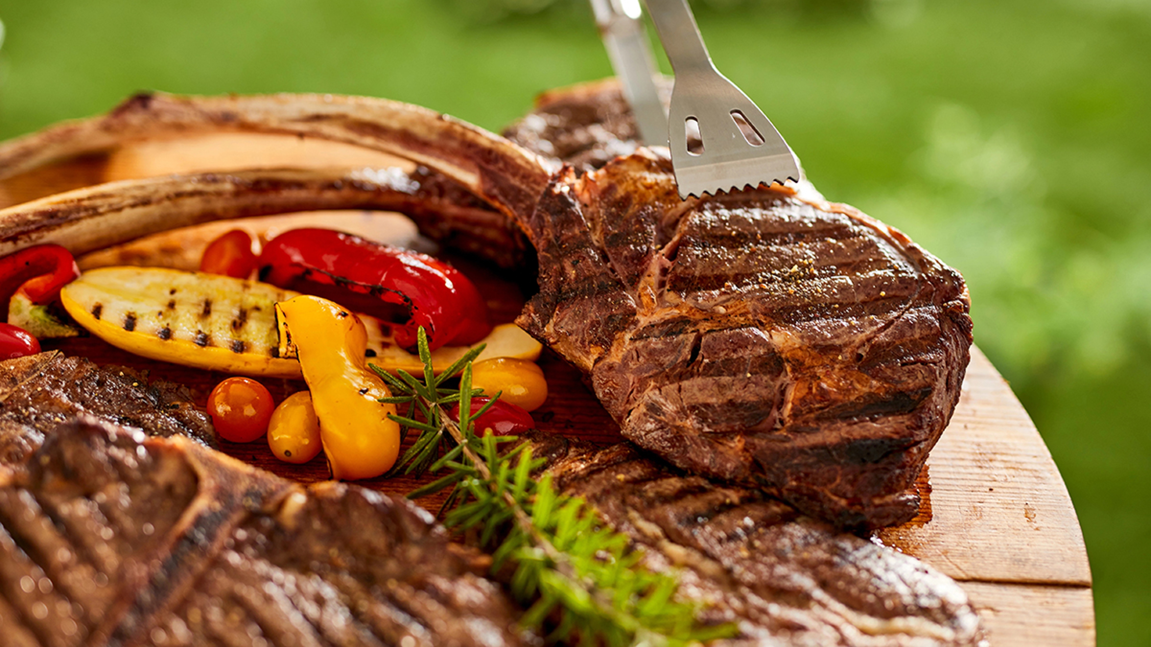 Article Cards Featured Image Cuts of Beef steaks just off the grill with grilled peppers on a serving board