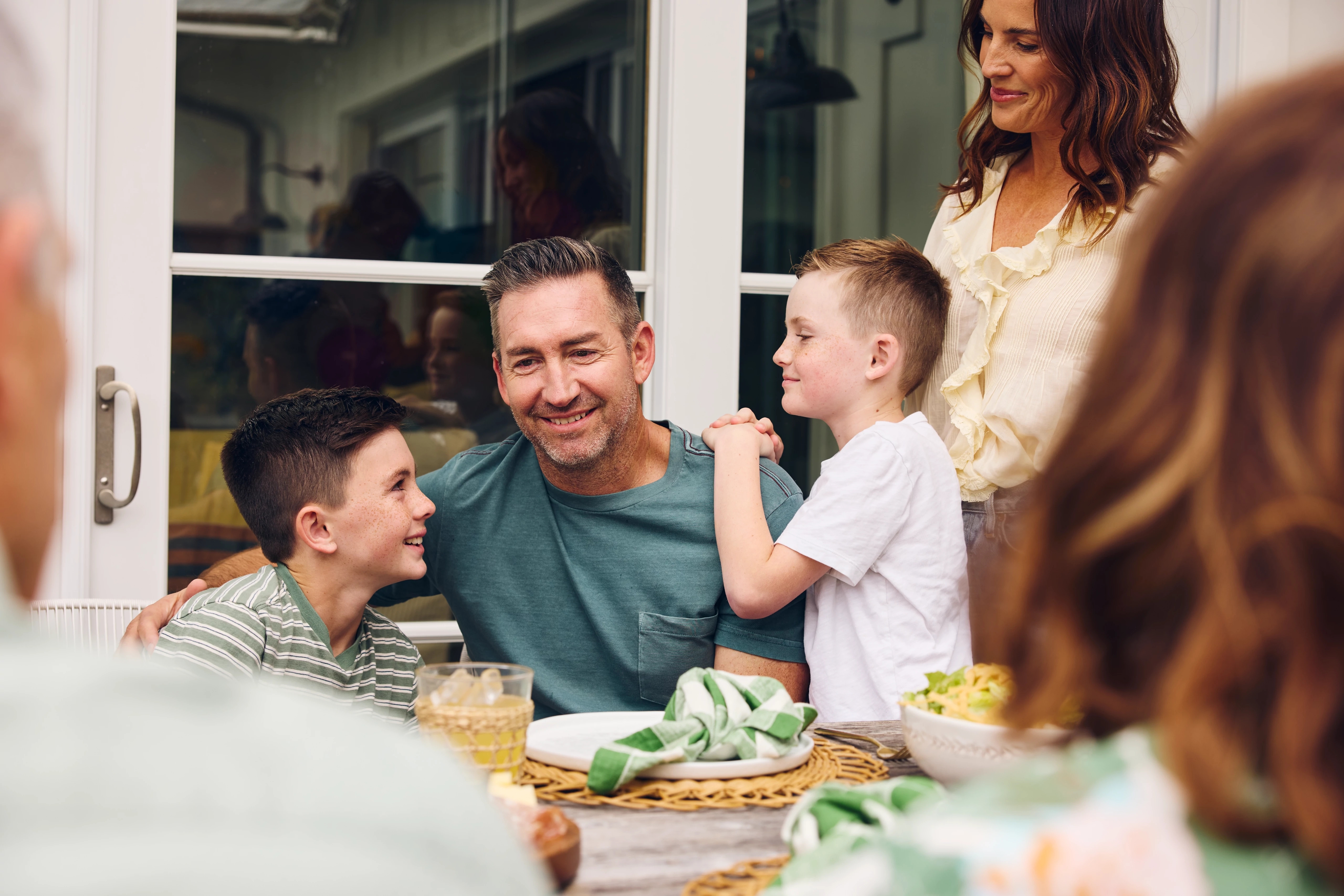 Article Cards Featured Image ways to celebrate fathers day dad with family around table outdoors