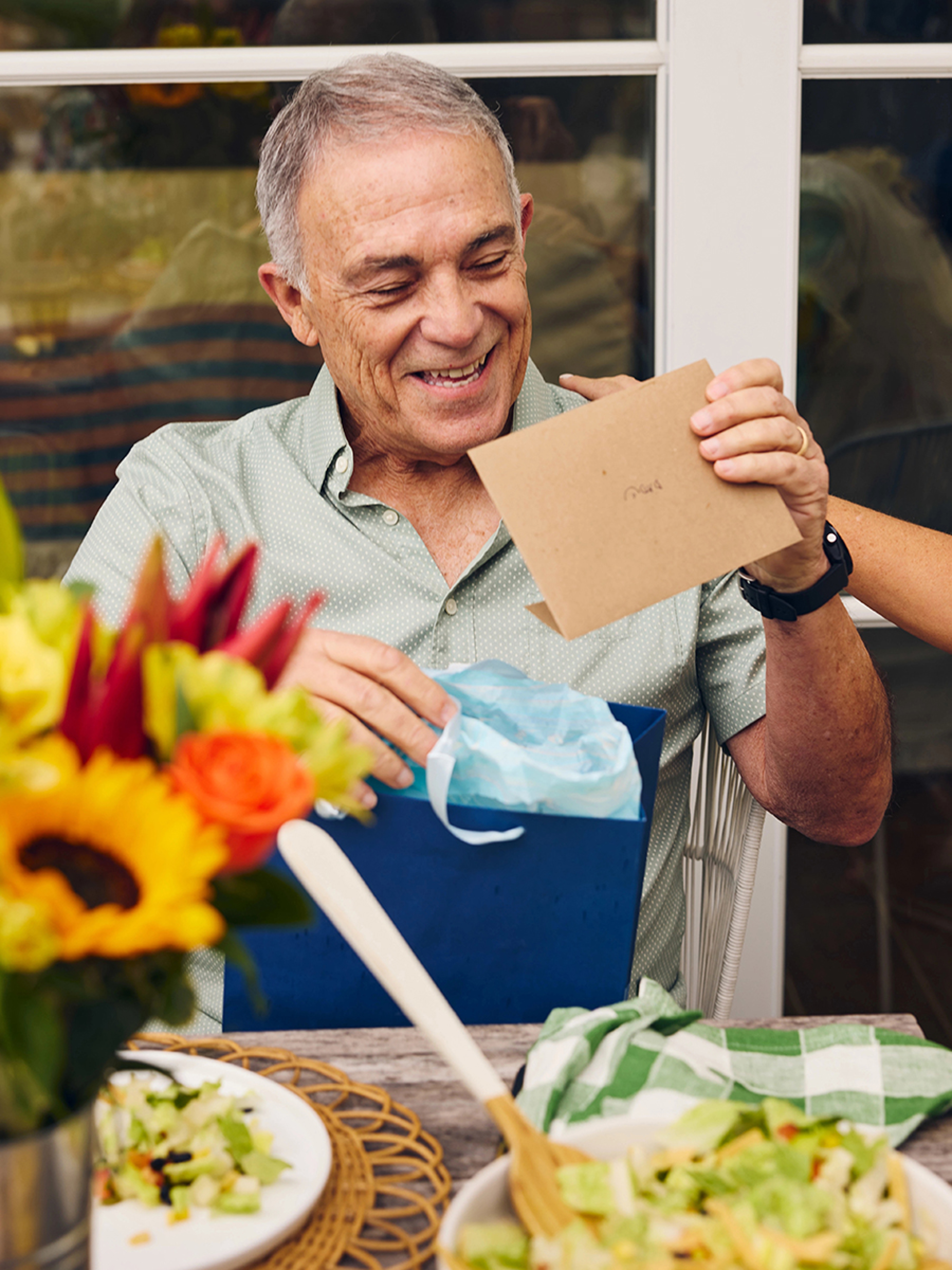 Retirement party with man opening a gift.