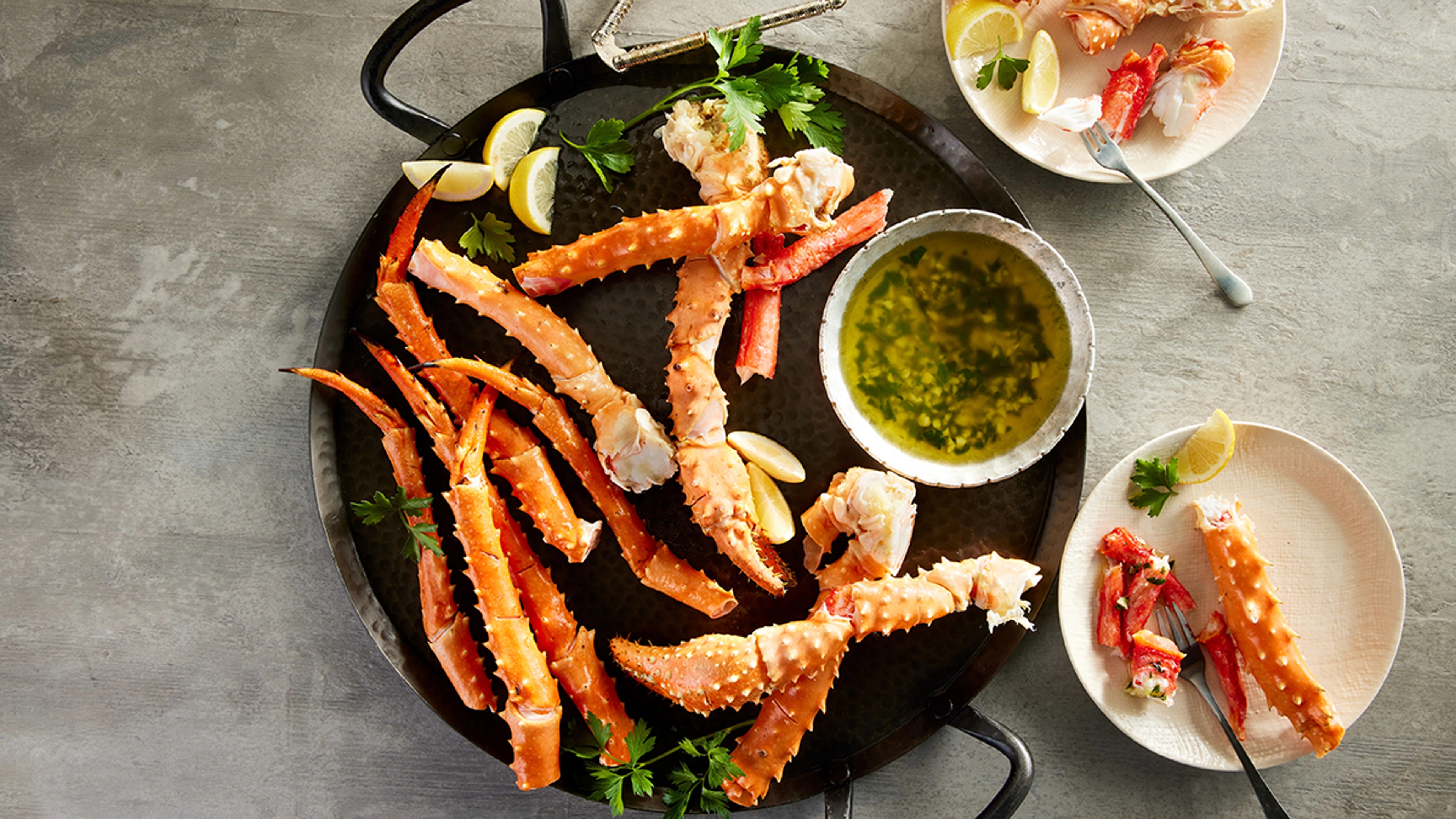 Golden king crab legs with dipping sauces.