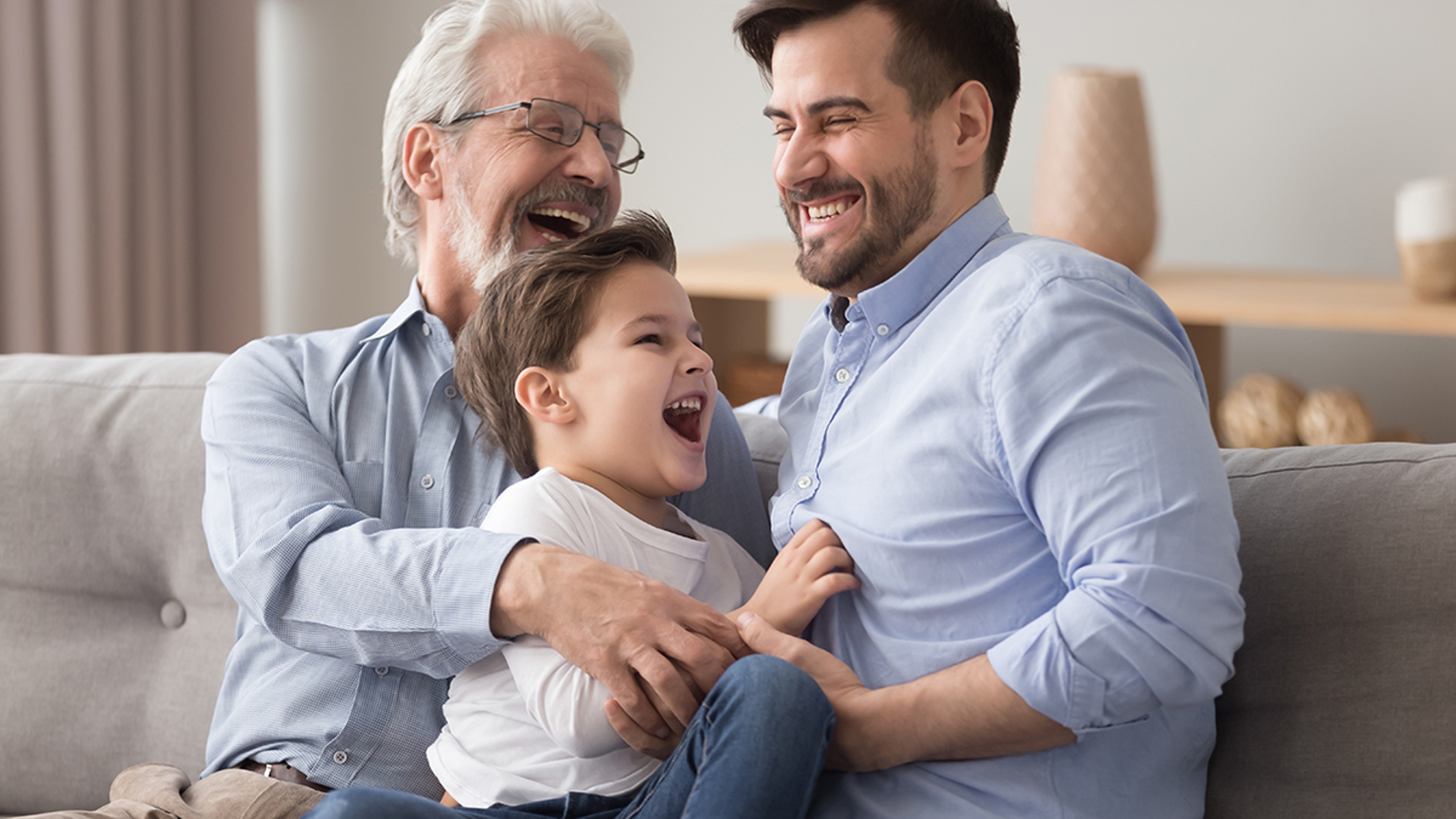 Article Cards Featured Image Happy grandfather and father tickling little boy, three generations of men having fun together, sitting on couch, laughing grandparent with son and grandchild relaxing spending weekend at home