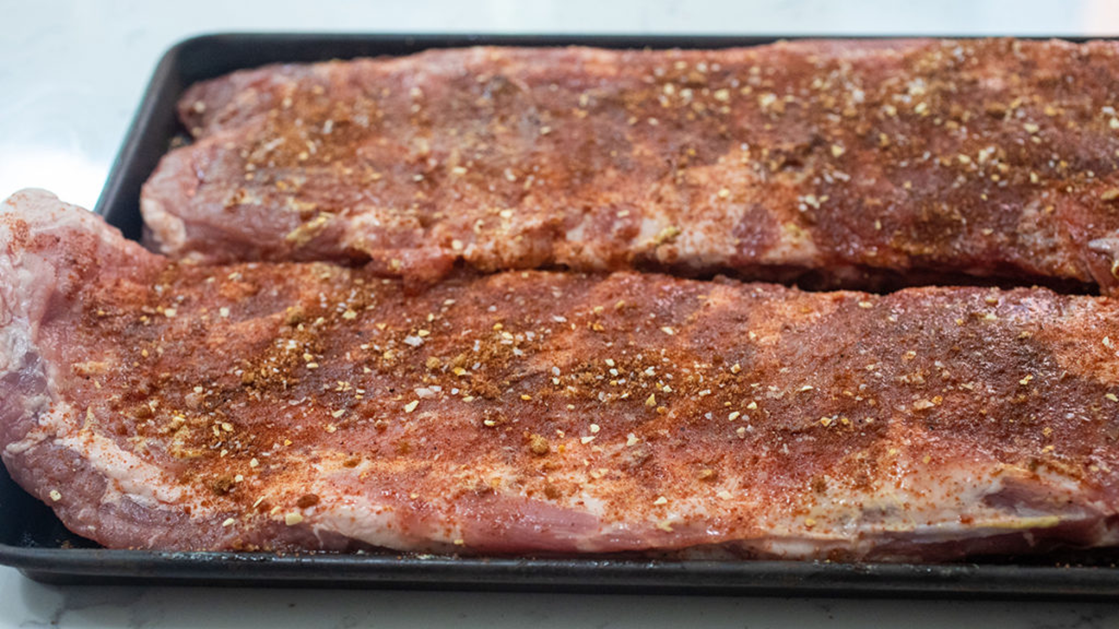 How to grill ribs with a sheet of raw pork ribs covered in seasoning.