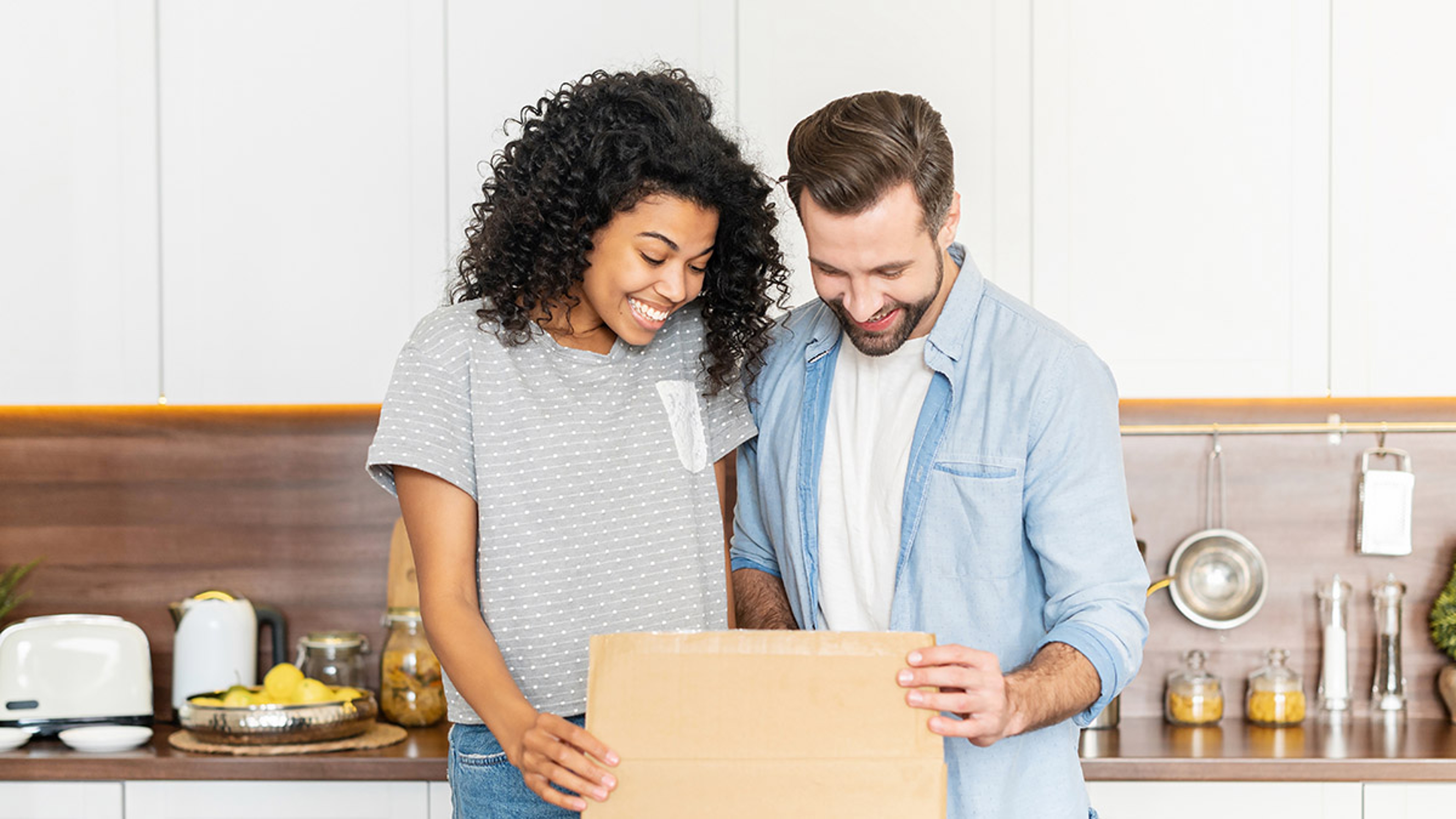 Article Cards Featured Image Happy interracial couple opening a carton box