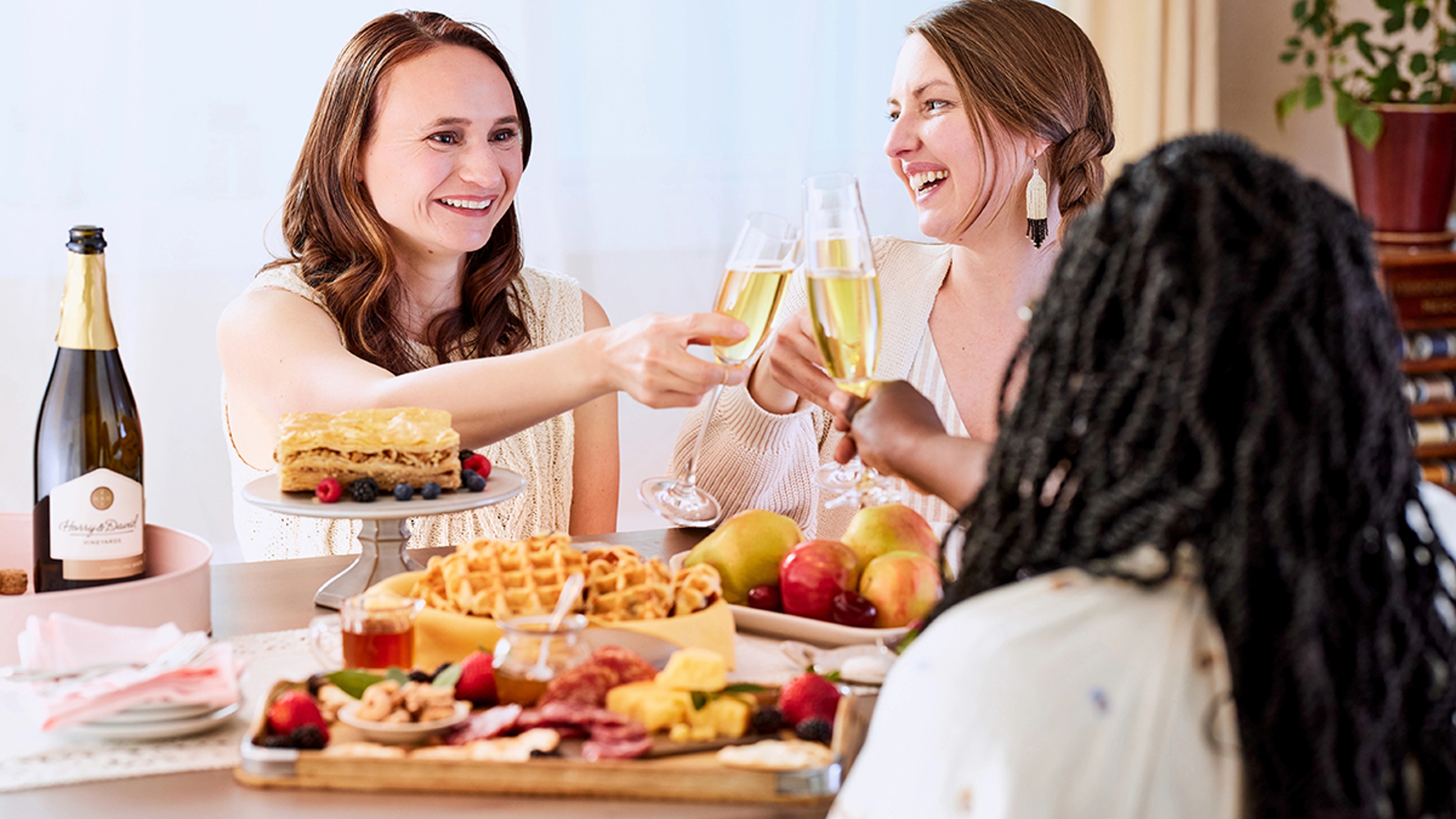 Women raising glasses at an alt bash brunch.