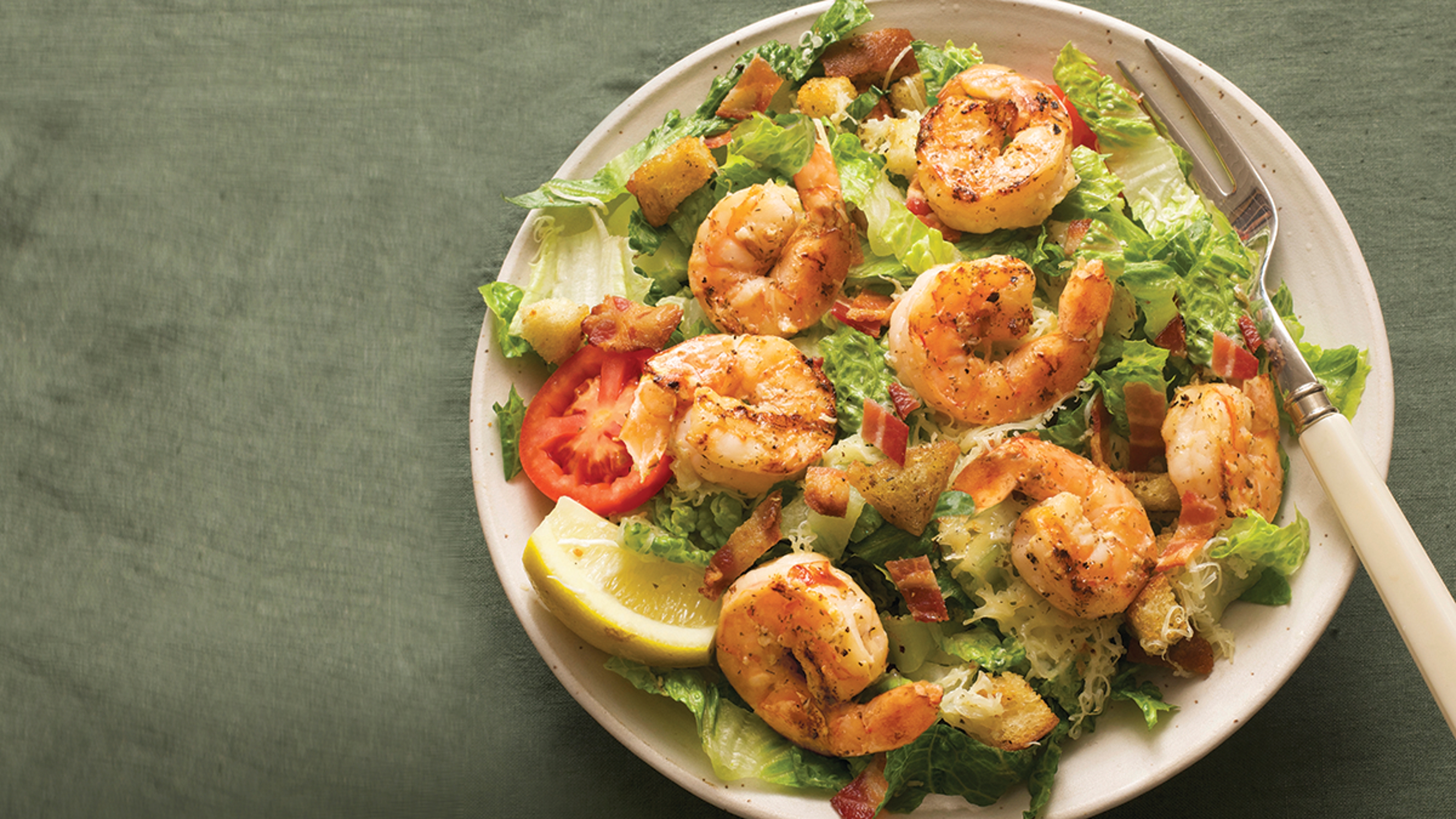 Closeup of a salad with grilled blue shrimp on top.