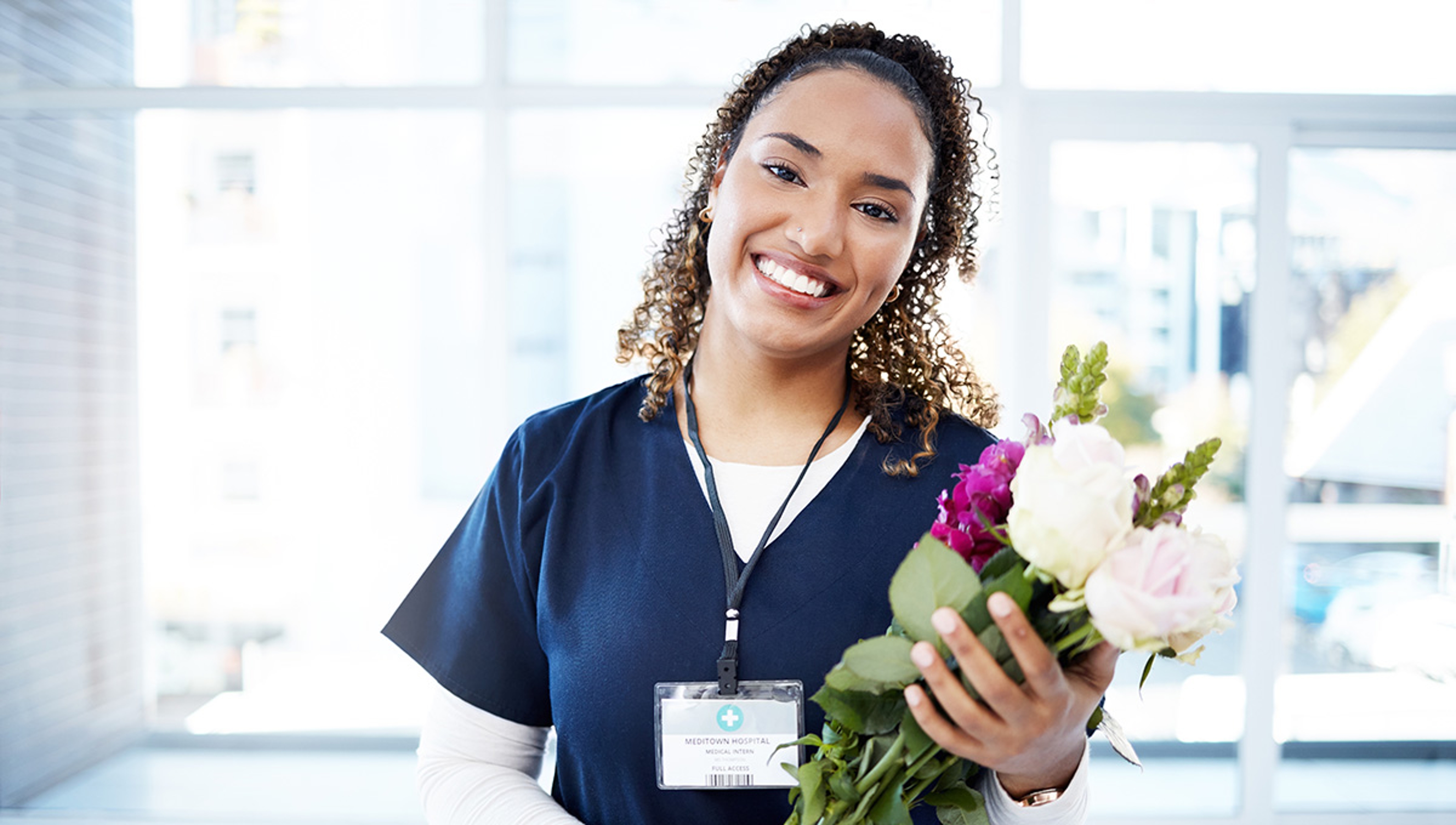 Article Cards Featured Image Success, celebration and portrait of doctor with flowers at a hospital for promotion and gift for work. Care, happy and female nurse with bouquet as a present for commitment in healthcare nursing job