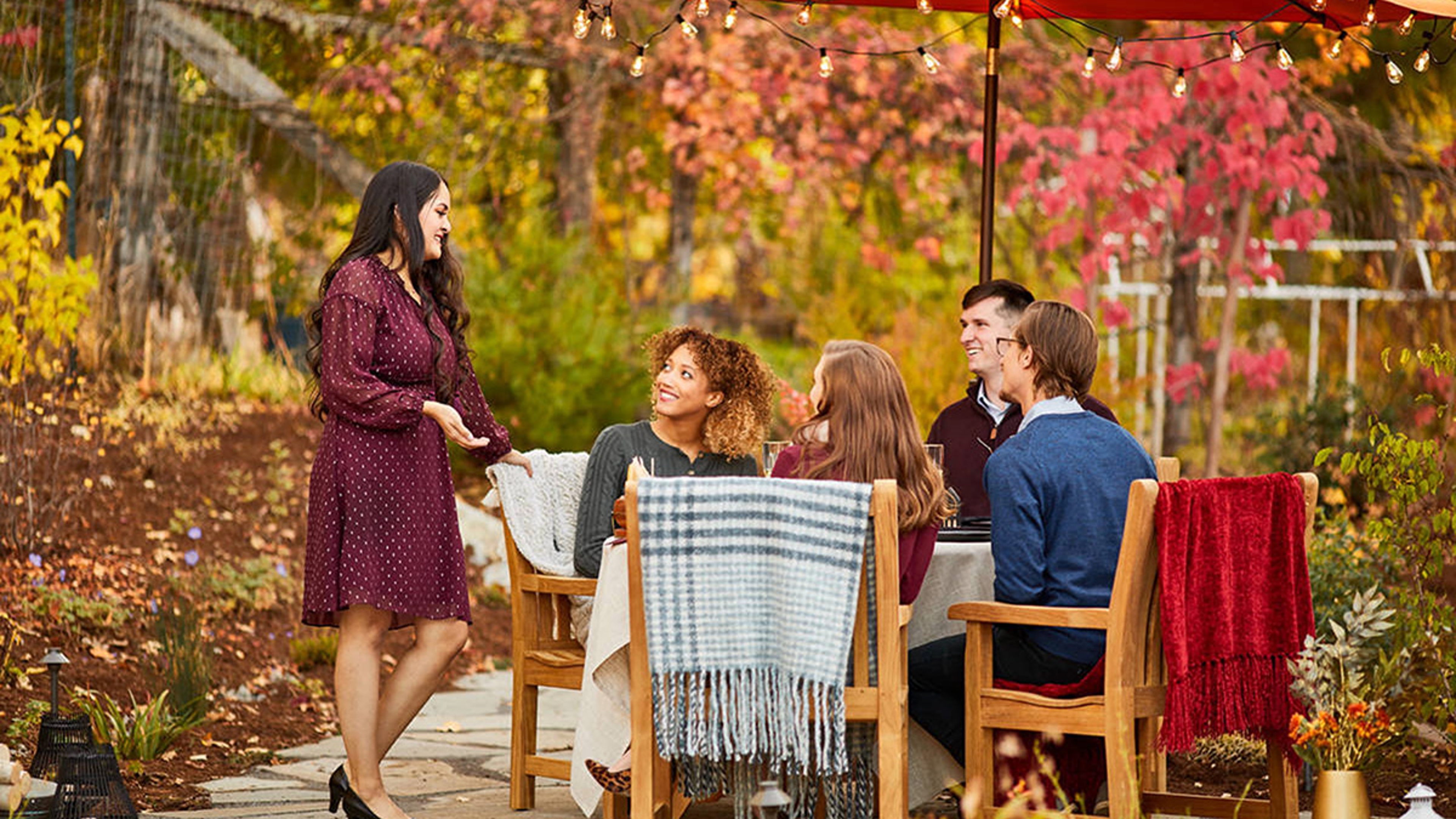 Group of adults sitting outside celebrating an October birthday.