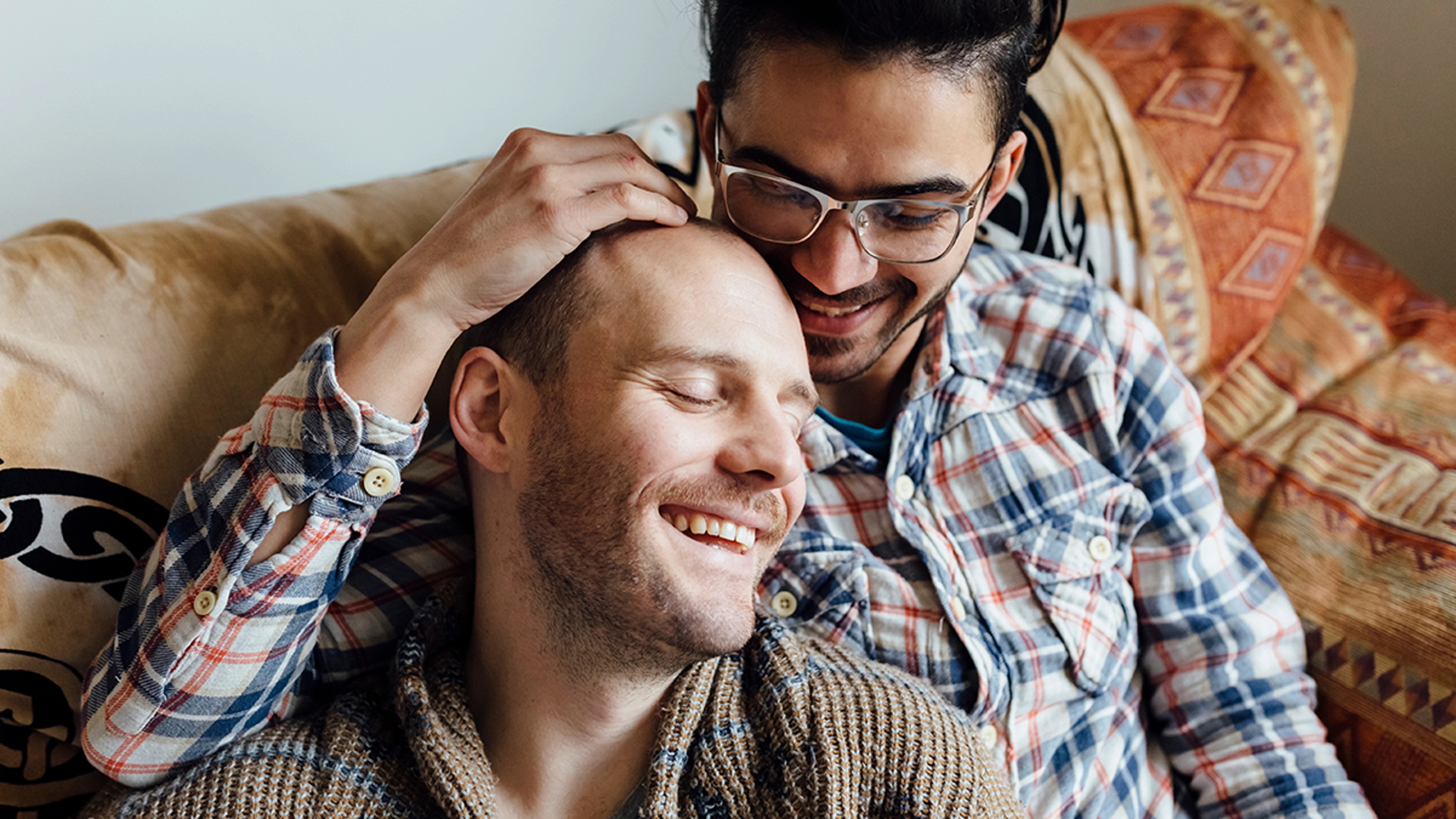 Couple snuggling on a couch.