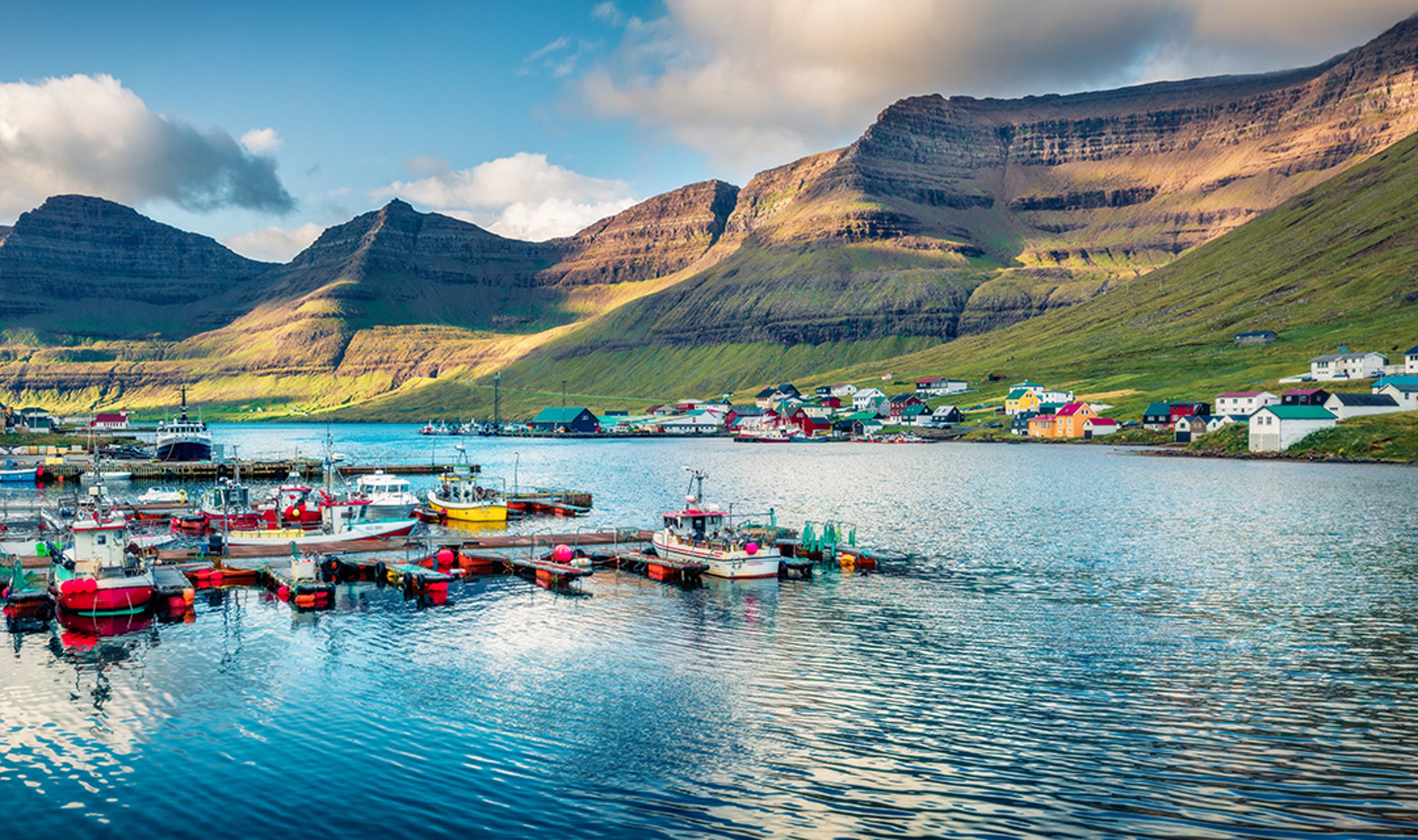 Panoramic morning view of Hvannasund port and village, Vidoy island. Calm summer scene of fjord on Atlantic ocean. Beautiful landscape of Faroe Islands, Kingdom of Denmark, Europe.