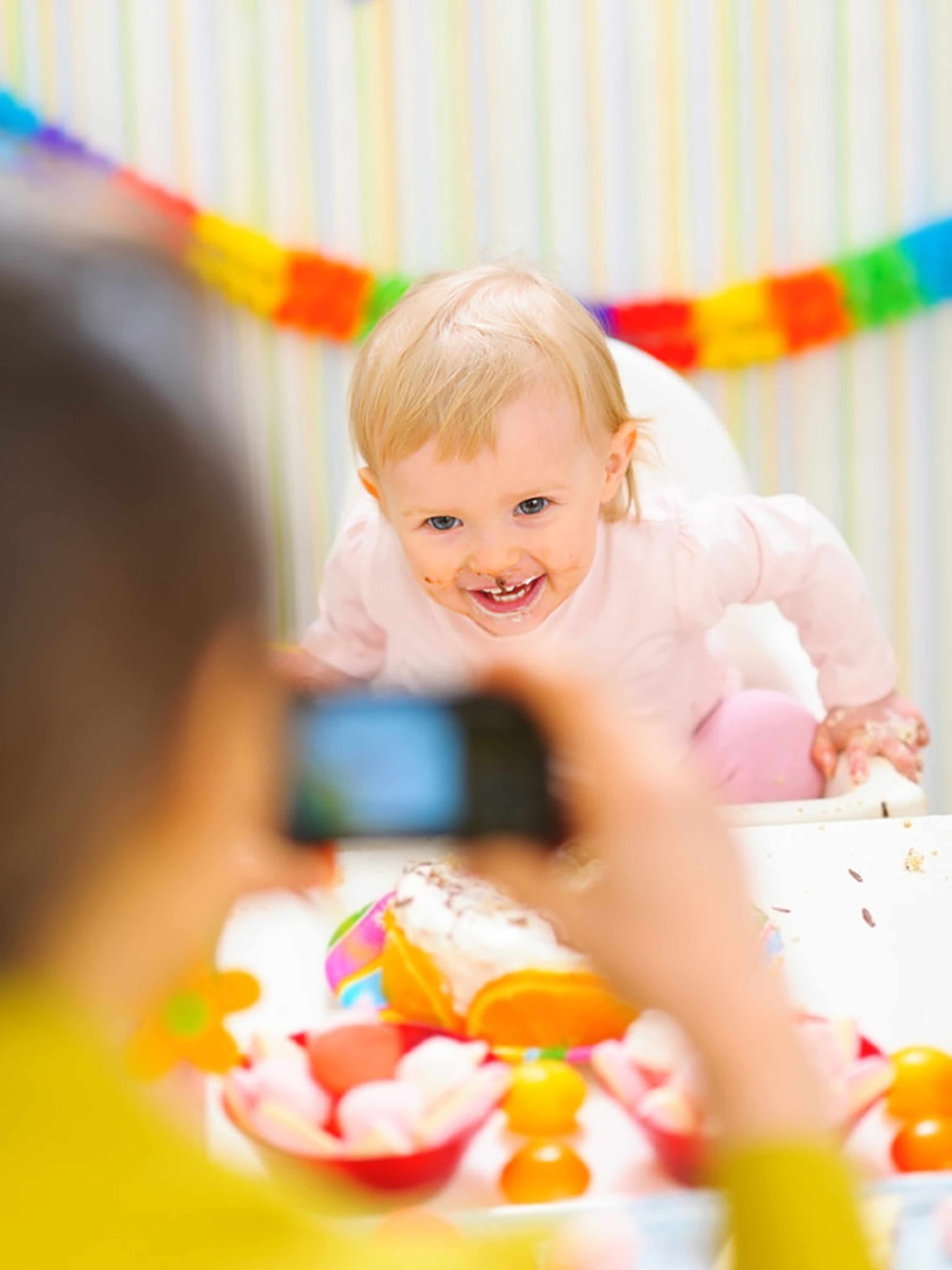 Child covered in cake smiling at camera.