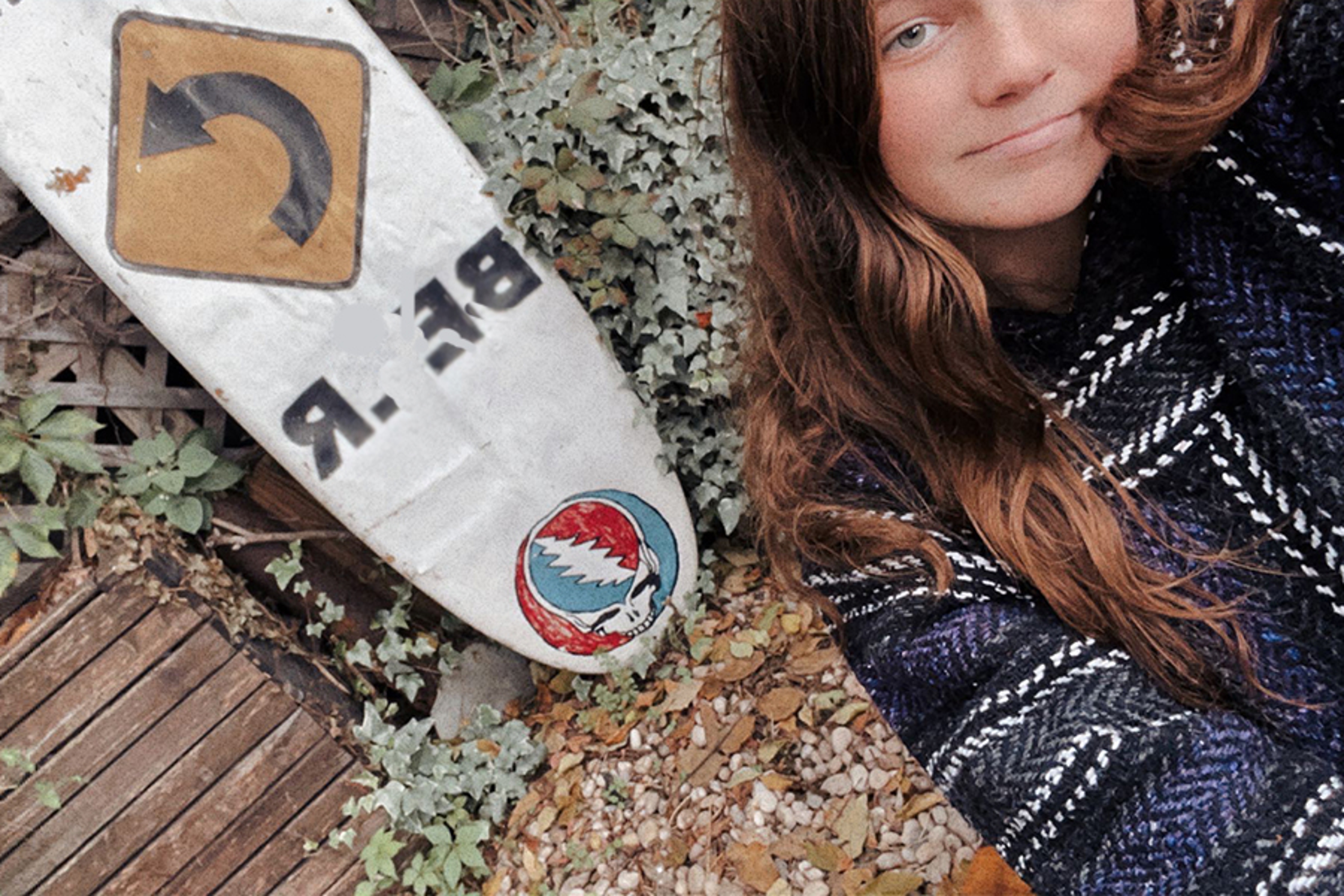 Women taking photo with surfboard in the background outside