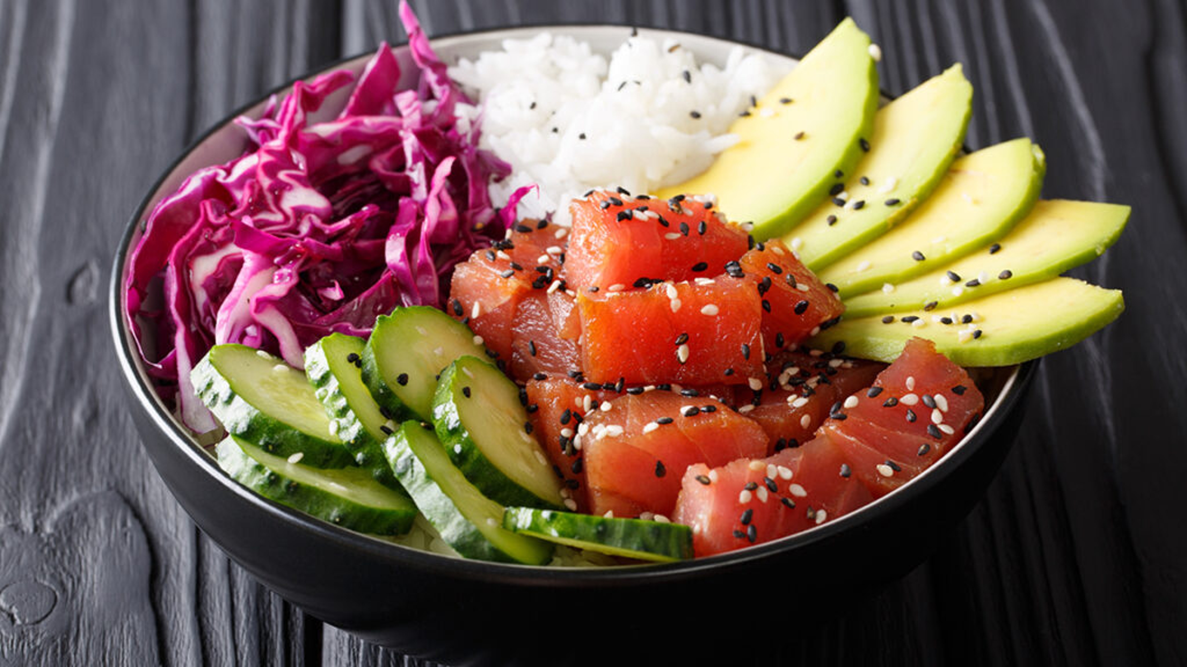 Poke bowl with tuna, rice, avocado, and vegetables.
