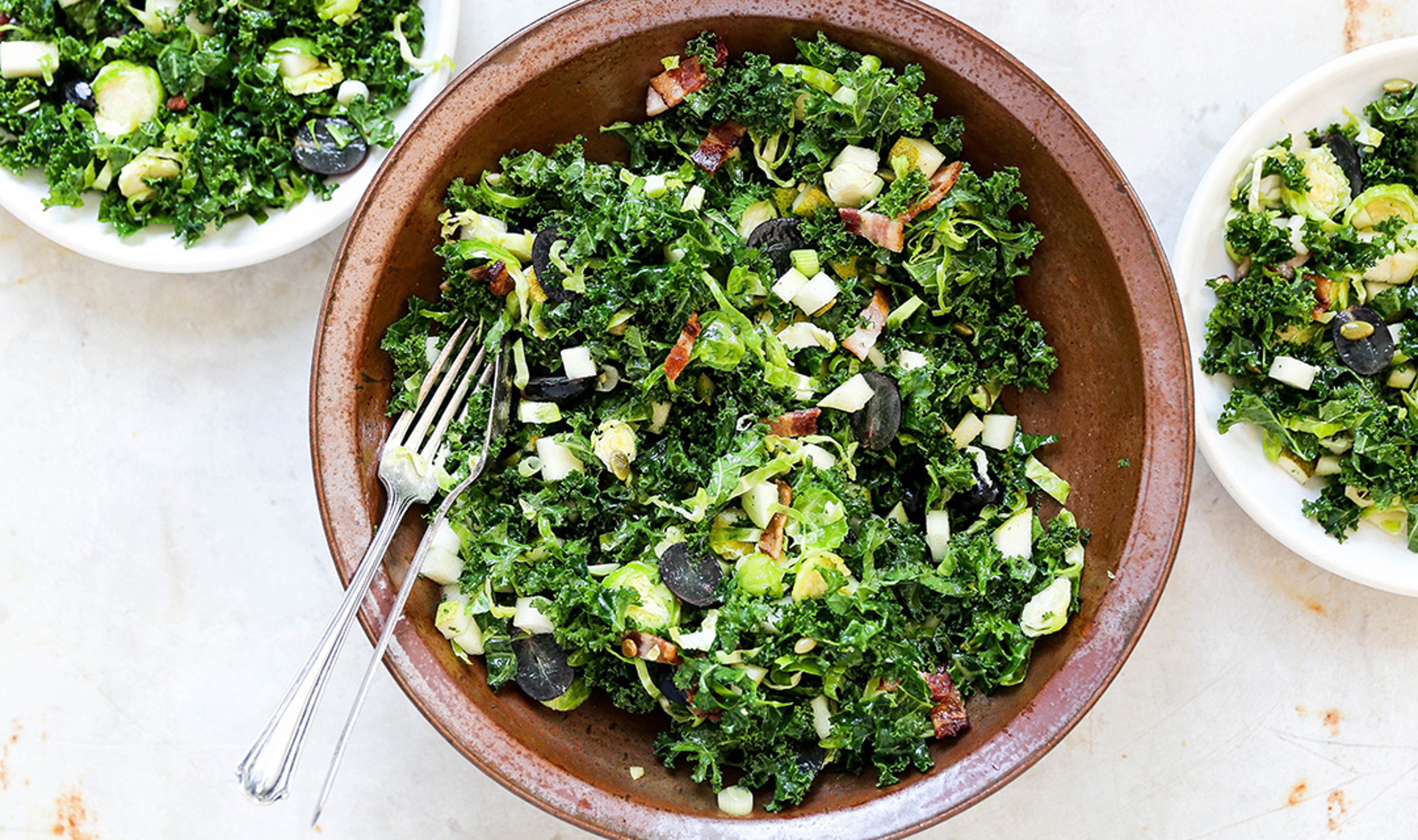 Shredded Kale and Brussels Sprouts Salad with Pears, Grapes, and Bacon