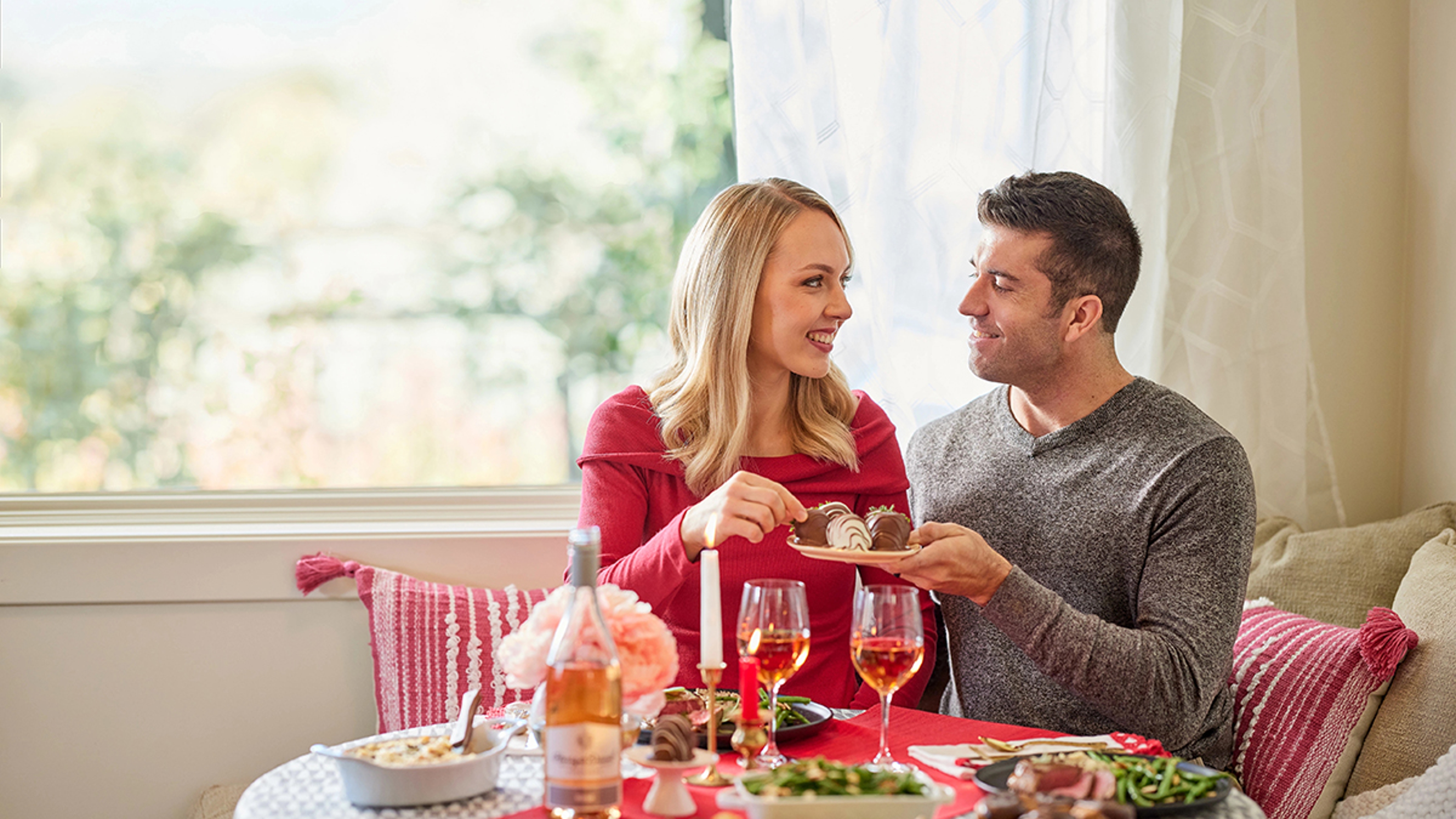 valentine's day gifts for her couple eating chocolate covered strawberries at kitchen table