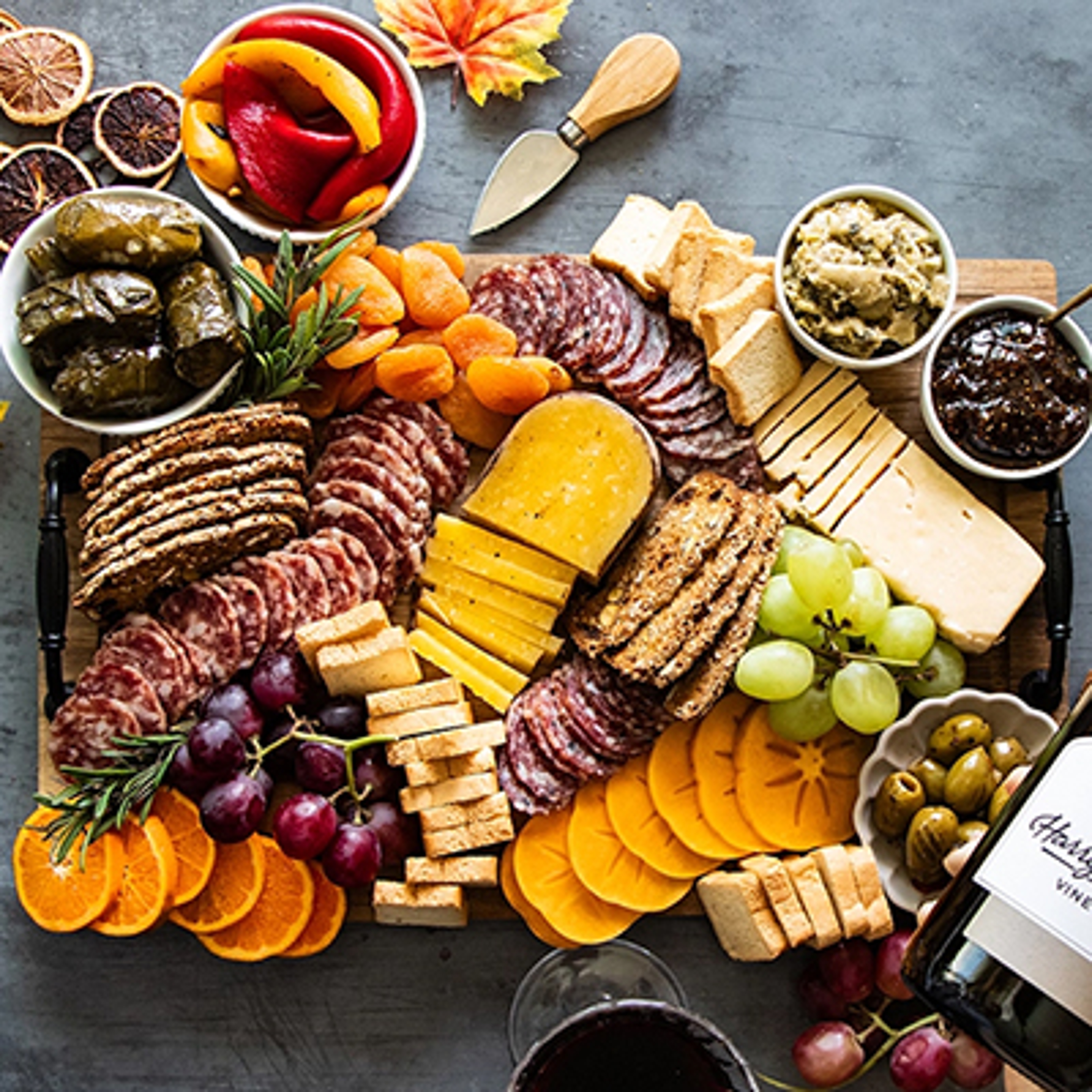 Fall charcuterie board with cheese, fruit, nuts, and other snacks.